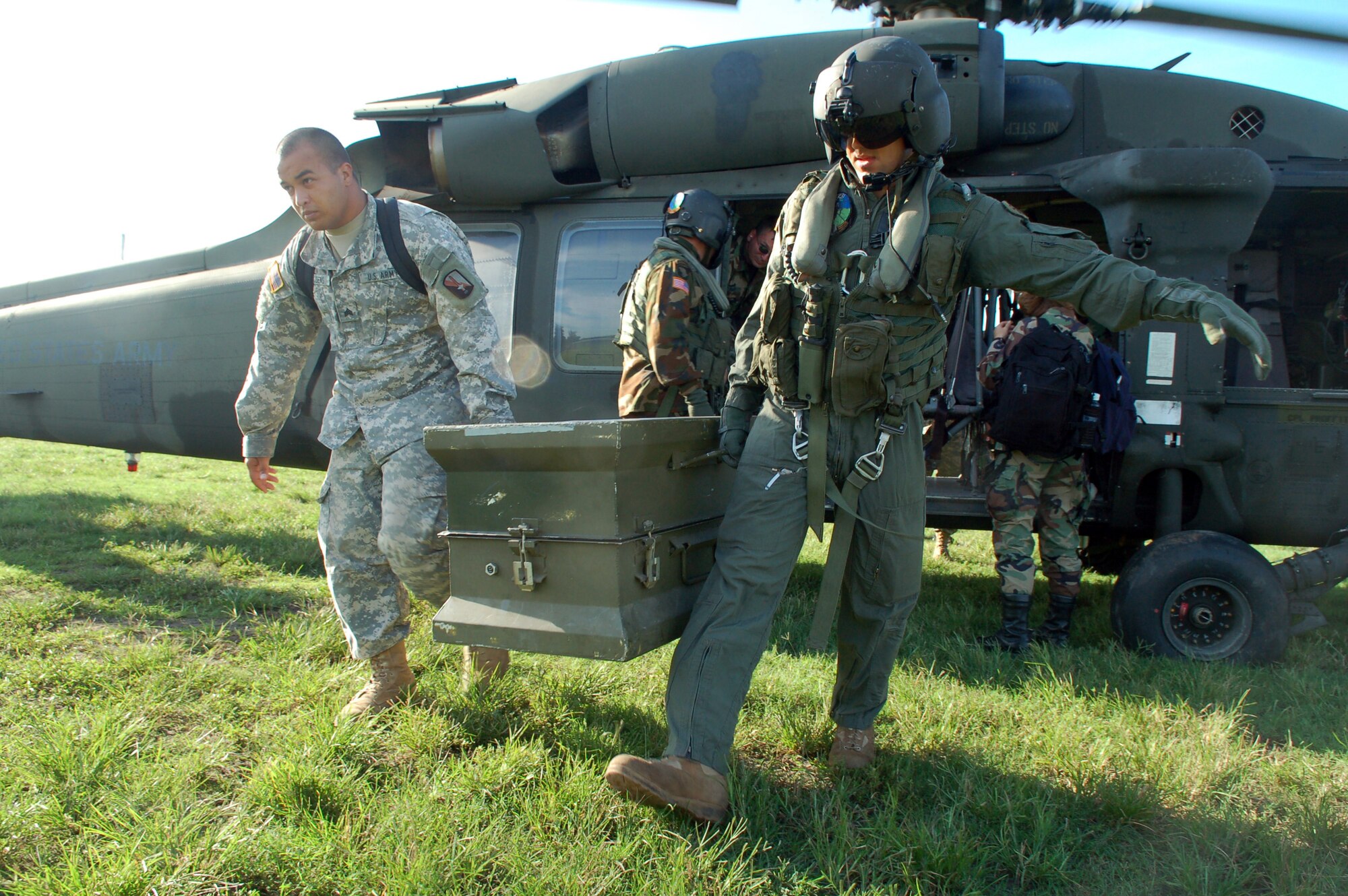 Dominican Republic -- Army Sgt. Warren Cassens and Spc. James Bilton carry a box full of medications from an Army UH-60 Black Hawk helicopter to a clinic set up by U.S. servicemembers from Joint Task Force-Bravo Nov. 10.  The pair are part of an Expeditionary Medical Liaison Team deployed to the Dominican Republic to provide medical assistance to the island nation.  (U.S. Air Force photo by Staff Sgt. Austin M. May)