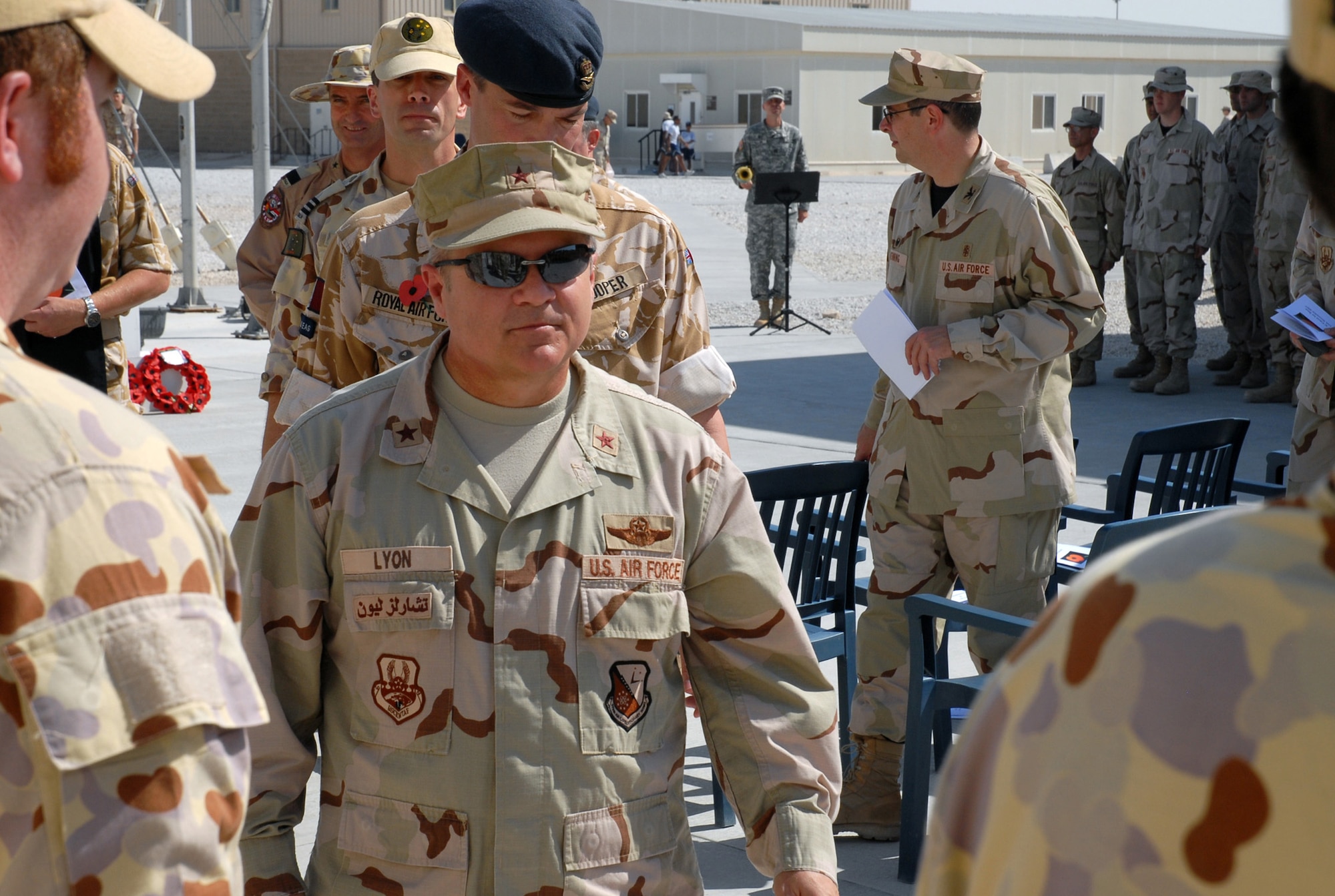 SOUTHWEST ASIA - Coalition forces from England, Australia and the United States gather to commemorate Remembrance Day and Veteran's Day Nov.11 at a Southwest Asia air base. Prayers and invocations were delivered by chaplains from each country represented in various denominations. Wreaths were laid at the memorial by representatives of the countries. Brig. Gen. Charlie Lyon, 379th Air Expeditionary Wing commander, departs after the close of the ceremony. (U. S. Air Force/Staff Sgt. Douglas Olsen)
