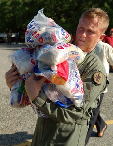 AZUA, Dominican Republic -- Army Specialist Ian Shaffer, a UH-60 crew chief with the 1st Battalion-228th Aviation Regiment deployed from Soto Cano Air Base, Honduras, carries a load of food to be delivered to one of three villages in the south-central region of the country Nov. 11.  As of Nov. 12, American and British aircrews had delivered more than 241,000 pounds of provisions to the island nation as part of a Combined, Joint, International relief effort following Tropical Storm Noel.  (U.S. Air Force photo by Staff Sgt. Austin M. May)