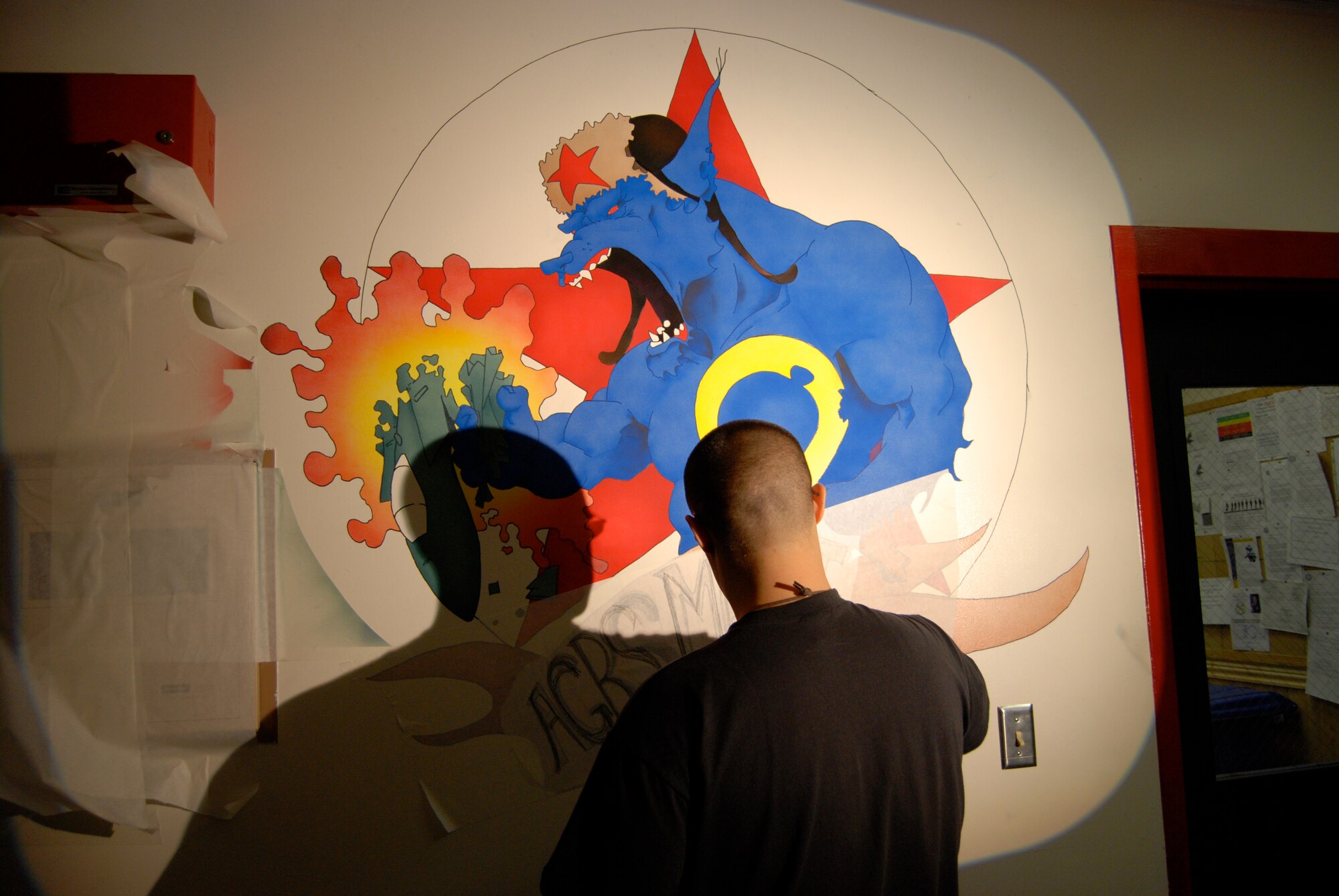 EIELSON AIR FORCE BASE, Alaska-- Senior Airman Benjamin Wood, 354th Aircraft Maintenance Squadron crew chief, paints the new mural of the Blue Fox for the 18th Aggressor Squadron Nov. 6 in a hallway of the 18th Aircraft Maintenance Unit building. The painting depicts a Blue Fox, the squadron's symbol, crushing an F-15, symbolizing the 18th's "bad-guy" reputation during training missions. (U.S. Air Force photo by Senior Airman Mark Eidschun) 