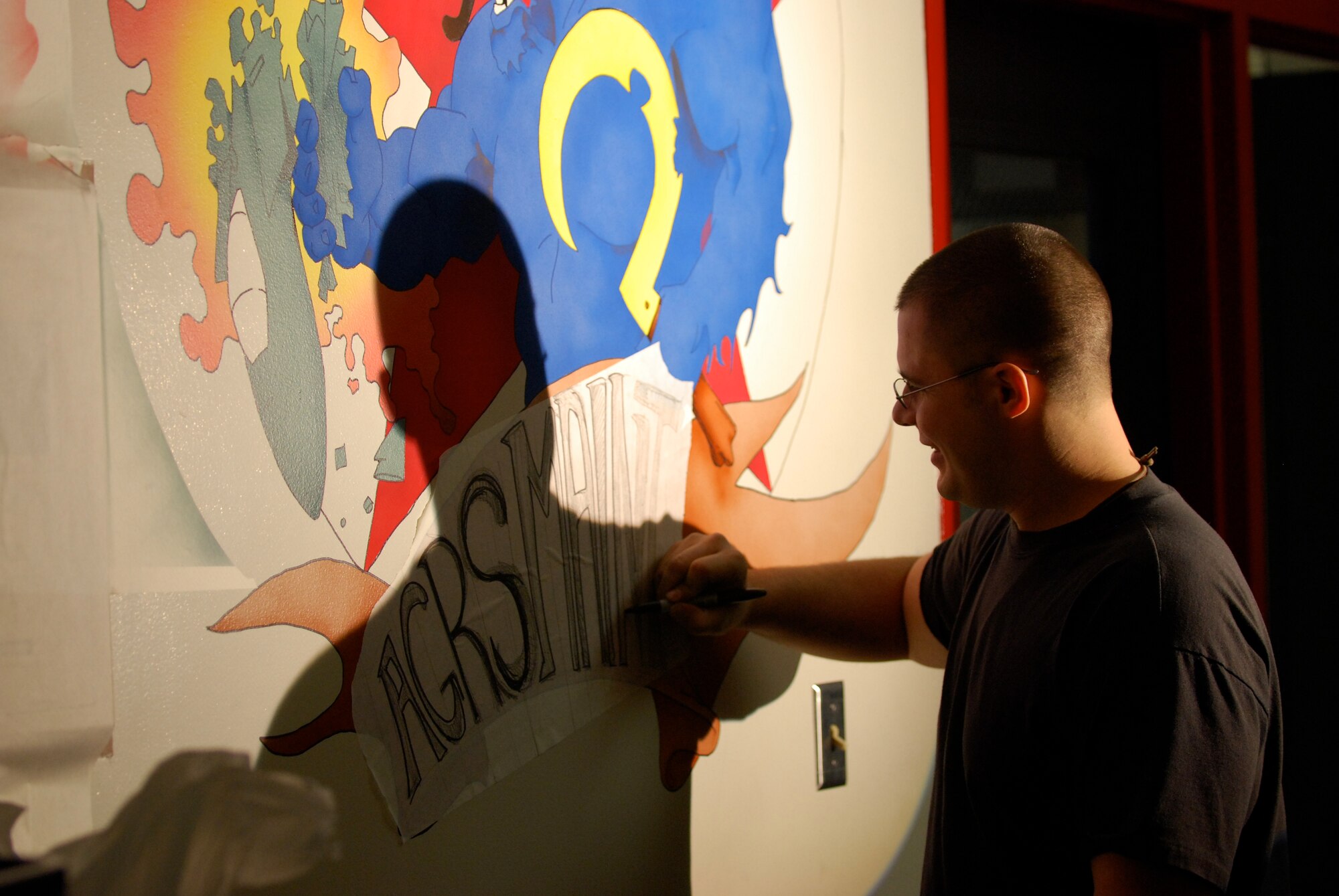 EIELSON AIR FORCE BASE, Alaska-- Senior Airman Benjamin Wood, 354th Aircraft Maintenance Squadron crew chief, paints the new mural of the Blue Fox for the 18th Aggressor Squadron Nov. 6 in a hallway of the 18th Aircraft Maintenance Unit building. The painting depicts a Blue Fox, the squadron's symbol, crushing an F-15, symbolizing the 18th's "bad-guy" reputation during training missions. (U.S. Air Force photo by Senior Airman Mark Eidschun) 