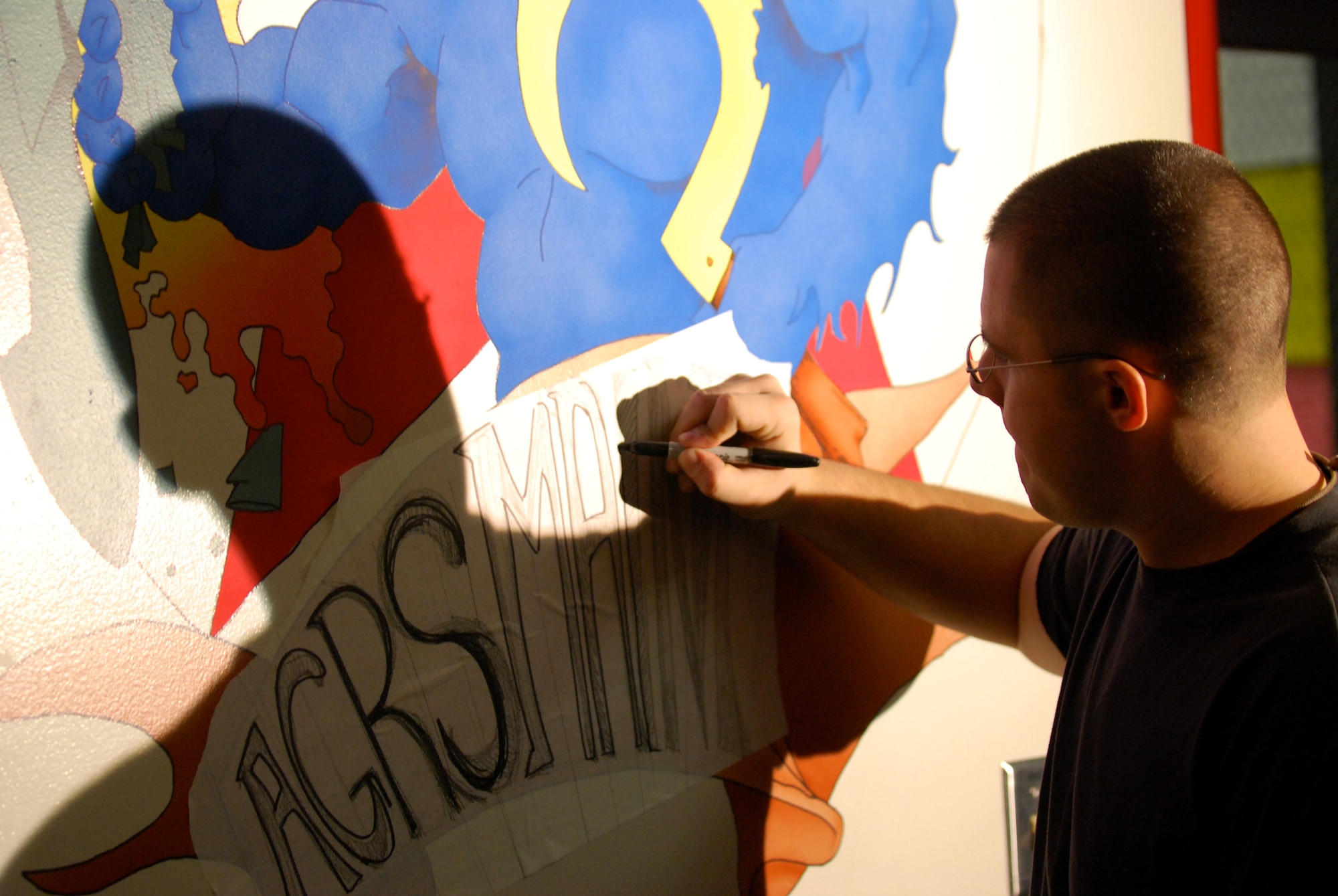 EIELSON AIR FORCE BASE, Alaska-- Senior Airman Benjamin Wood, 354th Aircraft Maintenance Squadron crew chief, paints the new mural of the Blue Fox for the 18th Aggressor Squadron Nov. 6 in a hallway of the 18th Aircraft Maintenance Unit building. The painting depicts a Blue Fox, the squadron's symbol, crushing an F-15, symbolizing the 18th's "bad-guy" reputation during training missions. (U.S. Air Force photo by Senior Airman Mark Eidschun) 