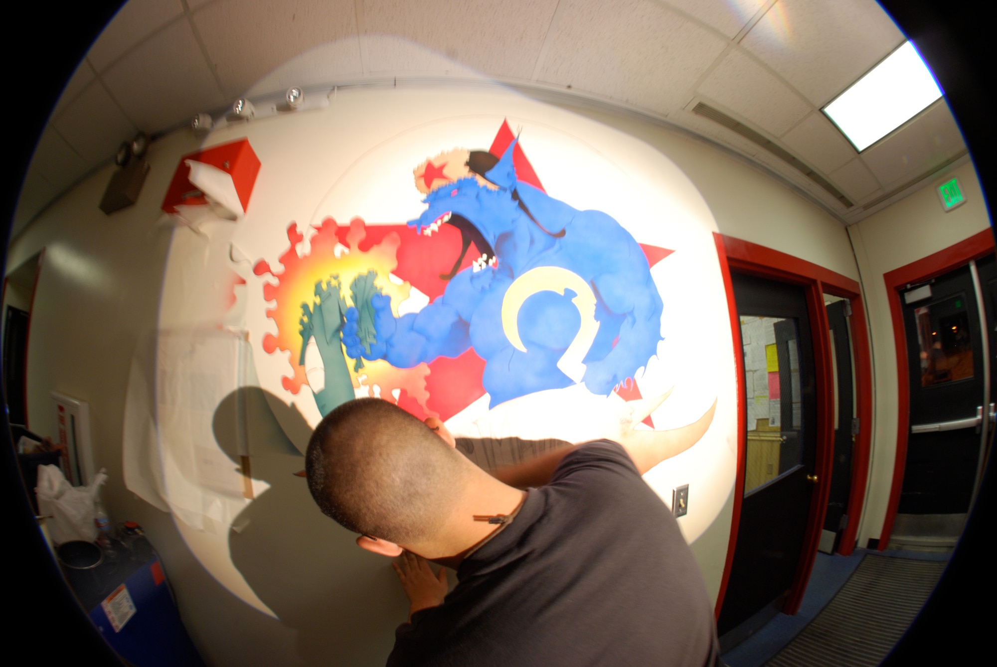 EIELSON AIR FORCE BASE, Alaska-- Senior Airman Benjamin Wood, 354th Aircraft Maintenance Squadron crew chief, paints the new mural of the Blue Fox for the 18th Aggressor Squadron Nov. 6 in a hallway of the 18th Aircraft Maintenance Unit building. The painting depicts a Blue Fox, the squadron's symbol, crushing an F-15, symbolizing the 18th's "bad-guy" reputation during training missions. (U.S. Air Force photo by Senior Airman Mark Eidschun) 