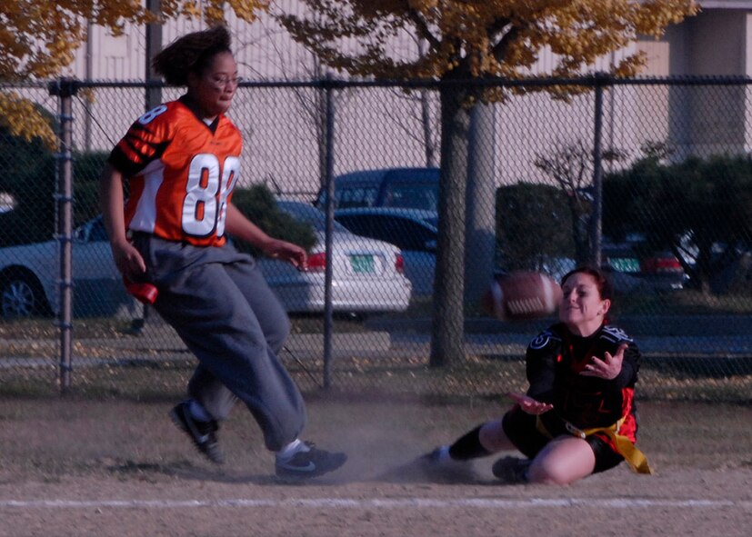KUNSAN AIR BASE, South Korea—  Senior Airman Rikki Crawford from the 8th Maintenance Squadron makes a catch to earn her team a first down while Staff Sgt. Lucia Romulus from the 8th Medical Group runs over to remove her flag here Nov. 12. The powder puff game was one of the Veterans Day events held to build moral among Wolf Pack members.  (U.S. Air Force photo/Staff Sgt. Araceli Alarcon)

                
