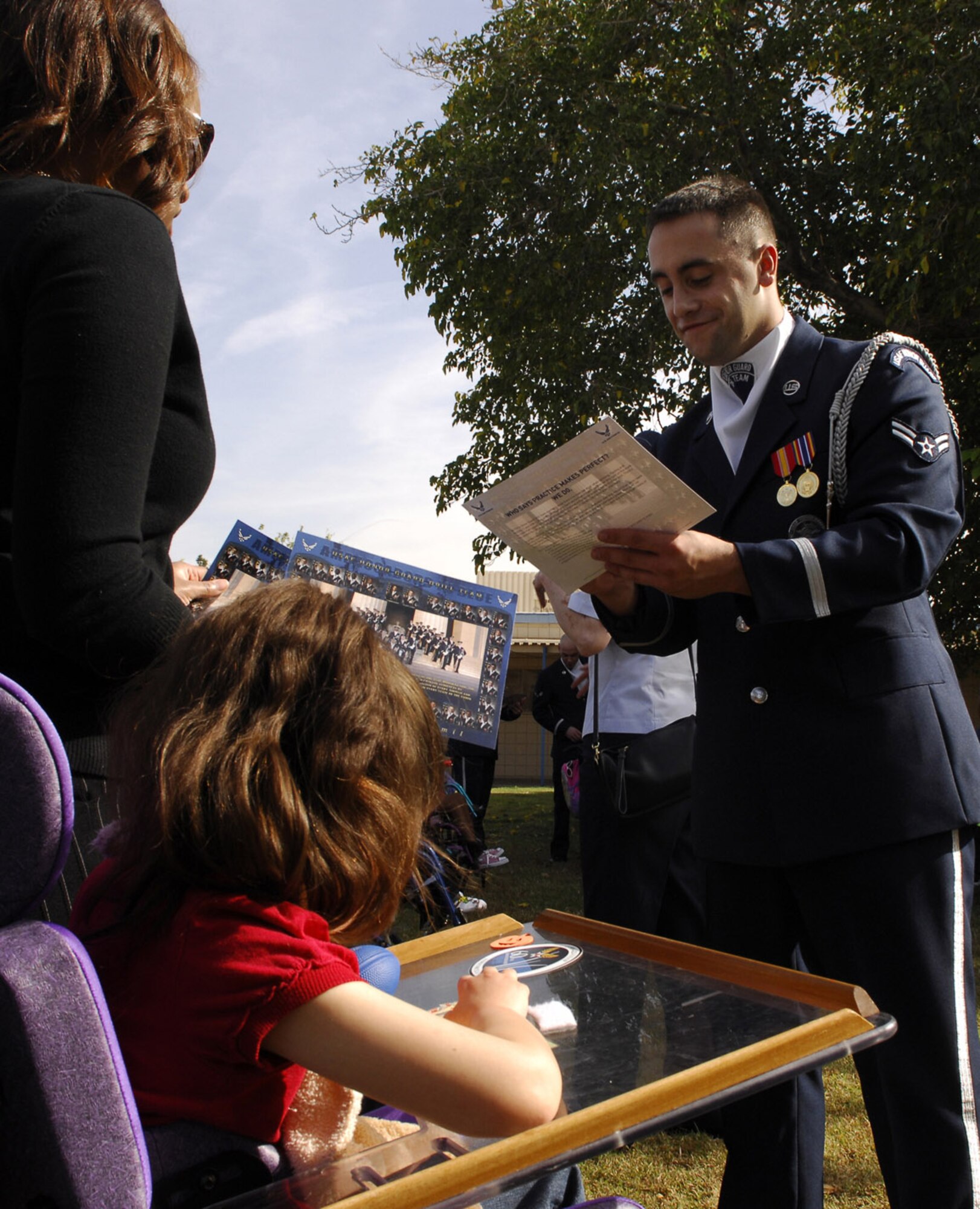 Airman 1st Class Peter Ising signs an autograph for a student at the John F. Miller School for Special Needs Nov. 8 in Las Vegas. Airman Ising is an Air Force Honor Guard drill team member. The drill team planned a special performance for the students at the school during their visit to the city and Nellis Air Force Base, Nev., for the final week of the Air Force's 60th Anniversary celebrations. (U.S. Air Force photo/Airman 1st Class Alexander Montes) 
