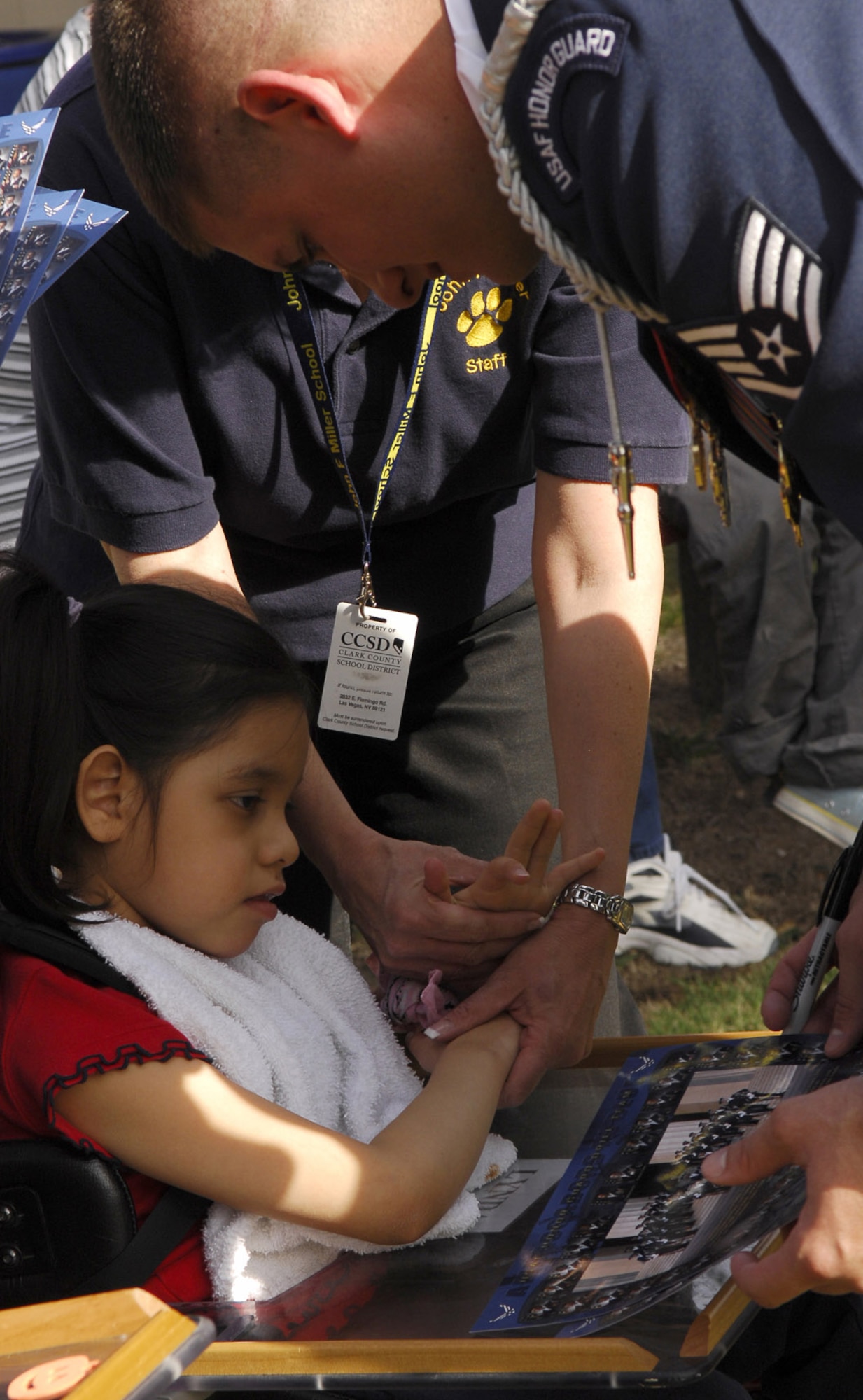 Staff Sgt. Michael Doss signs an autograph for a student at the John F. Miller School for Special Needs Nov. 8 in Las Vegas. Sergeant Doss is an Air Force Honor Guard drill team member. The drill team planned a special performance for the students at the school during their visit to the city and Nellis Air Force Base, Nev., for the final week of the Air Force's 60th Anniversary celebrations. (U.S. Air Force photo/Airman 1st Class Alexander Montes) 
