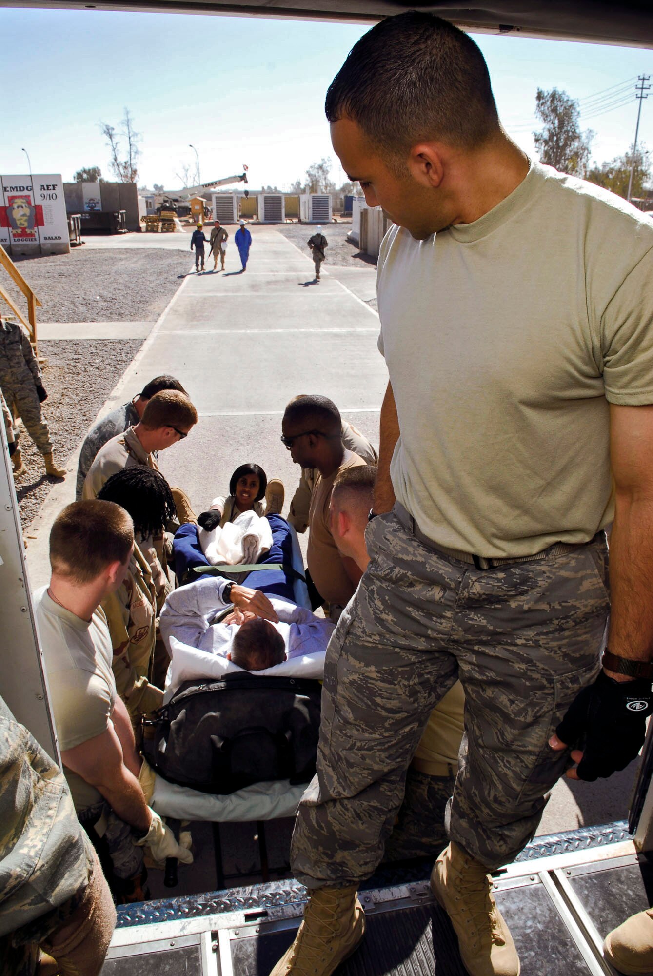 Staff. Sgt. Joan Sanchez prepares to load a patient aboard an ambulance bus from volunteers Nov. 13 at Balad Air Base, Iraq. Air Force Theater Hospital volunteers from throughout the base help the Contingency Aeromedical Staging Facility staff load and secure patients. Sergeant Sanchez, a 332nd Expeditionary Aerospace Medical Squadron aerospace medical technician, is deployed from Langley Air Force Base, Va. (U.S. Air Force photo/Staff Sgt. Joshua Garcia)