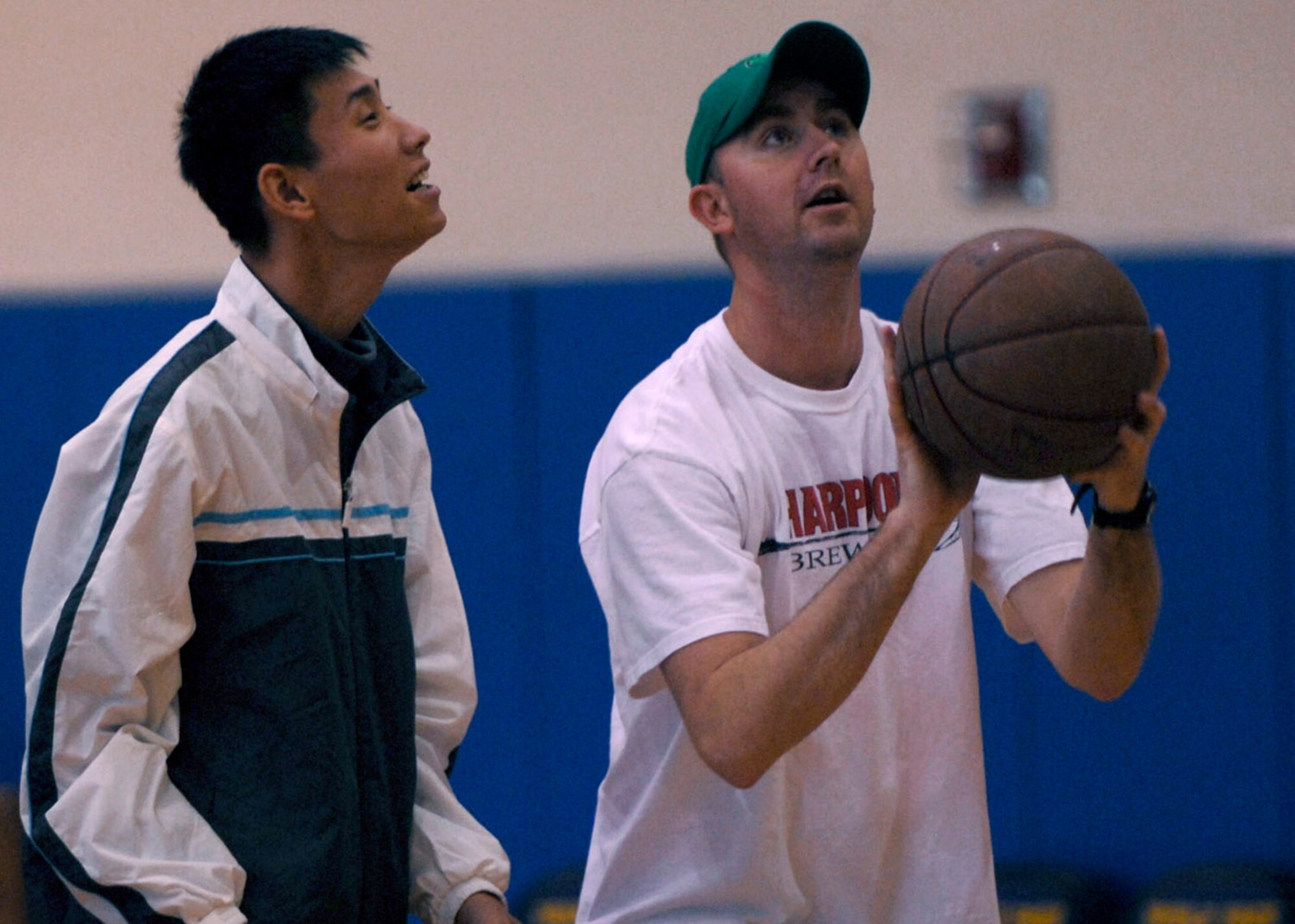 1st Lt. Bill Chalmers teaches a young man how to shoot a basket at the fitness center Nov. 10 at Kunsan Air Base, South Korea. Airmen held a day of games and food for the local nationals. The good Neighbor program is designed for the base to actively engage with the local community to strengthen ties. Lieutenant Chalmers is the 8th Medical Group chief of laboratory services. (U.S. Air Force photo/Staff Sgt. Araceli Alarcon) 
