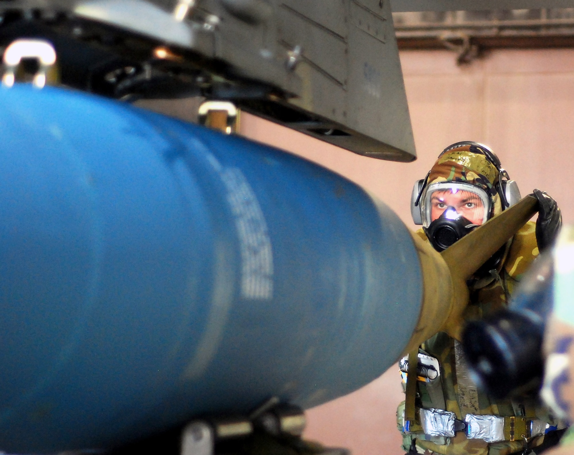Senior Airman Garrett Deese aligns bomb lugs for a MOPP 4 MK-84 load during the Peninsula Operational Readiness Exercise Nov. 8 at Kunsan Air Base, South Korea. The exercise was conducted to ensure base members remain ready to execute its mission. Airman Deese is an 8th Aircraft Maintenance Squadron weapons load crew member. (U.S. Air Force photo/Chief Master Sgt. William McElligott)