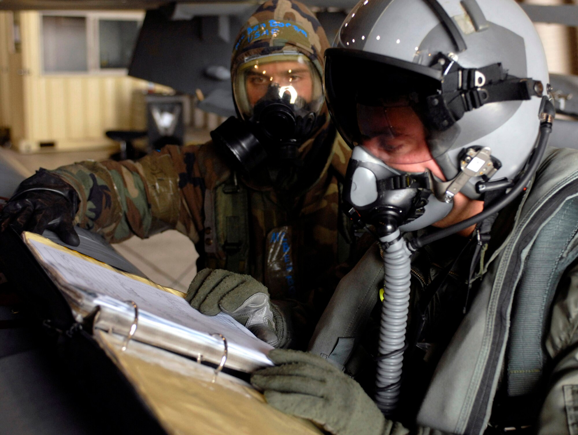 Capt. Darin Wetzler and Airman 1st Class Ben Borzym review a checklist prior to takeoff during the Peninsula Operational Readiness Exercise Nov. 6 at Kunsan Air Base, South Korea. The exercise tests the wing's ability to train and work in real-world situations. Captain Wetzler is a pilot with the 80th Fighter Squadron, and Airman Borzym is a crew chief with the 8th Aircraft Maintenance Squadron. (U.S. Air Force photo/Senior Airman Steven R. Doty) 
