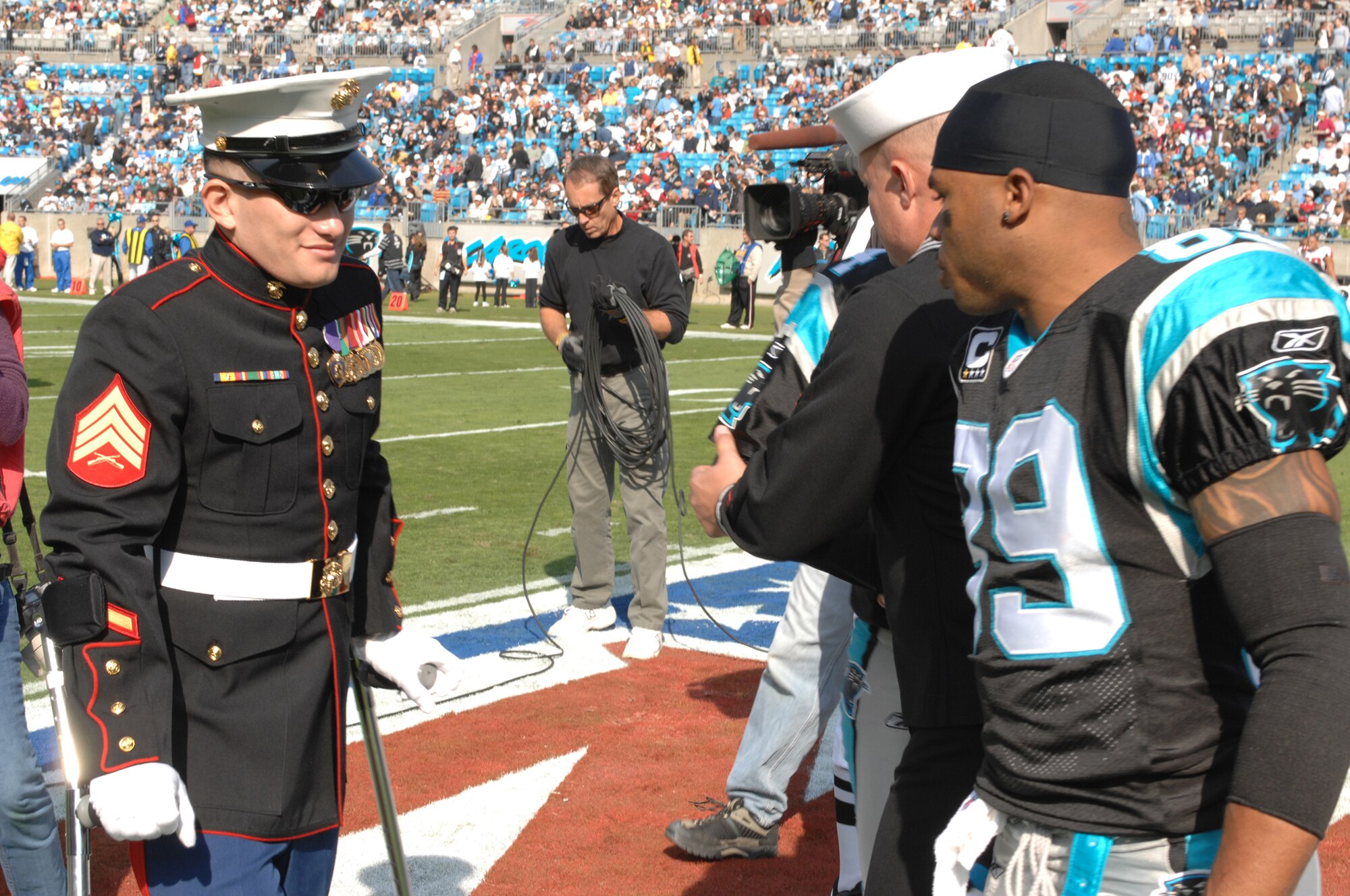 CHARLOTTE, N.C. -- Carolina Panthers wide receiver, Steve Smith, meets with Navy Hospital Corpsman William Cooper and Marine Sgt. Edwin Bono Nov. 11. Bono and Cooper, injured in Iraq, were named honorary team captains in honor of Veterans Day. "Without them, we wouldn't have the opportunity to do what we do," said Smith. (U.S. Air Force photo/Staff Sgt. Henry Hoegen)