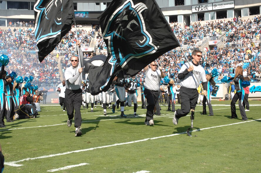 CHARLOTTE, N.C. -- In honor of Veterans Day, members of the Wounded Warrior Project lead the Carolina Panthers onto the field Nov. 11 before the Panthers/Falcons game. The mission of the Wounded Warrior Project is to raise public awareness and enlist the public's aid for the needs of severely injured service men and women, to help severely injured service members to aid and assist each other and to provide unique, direct programs and services to meet their needs. (U.S. Air Force photo/Staff Sgt. Henry Hoegen)
