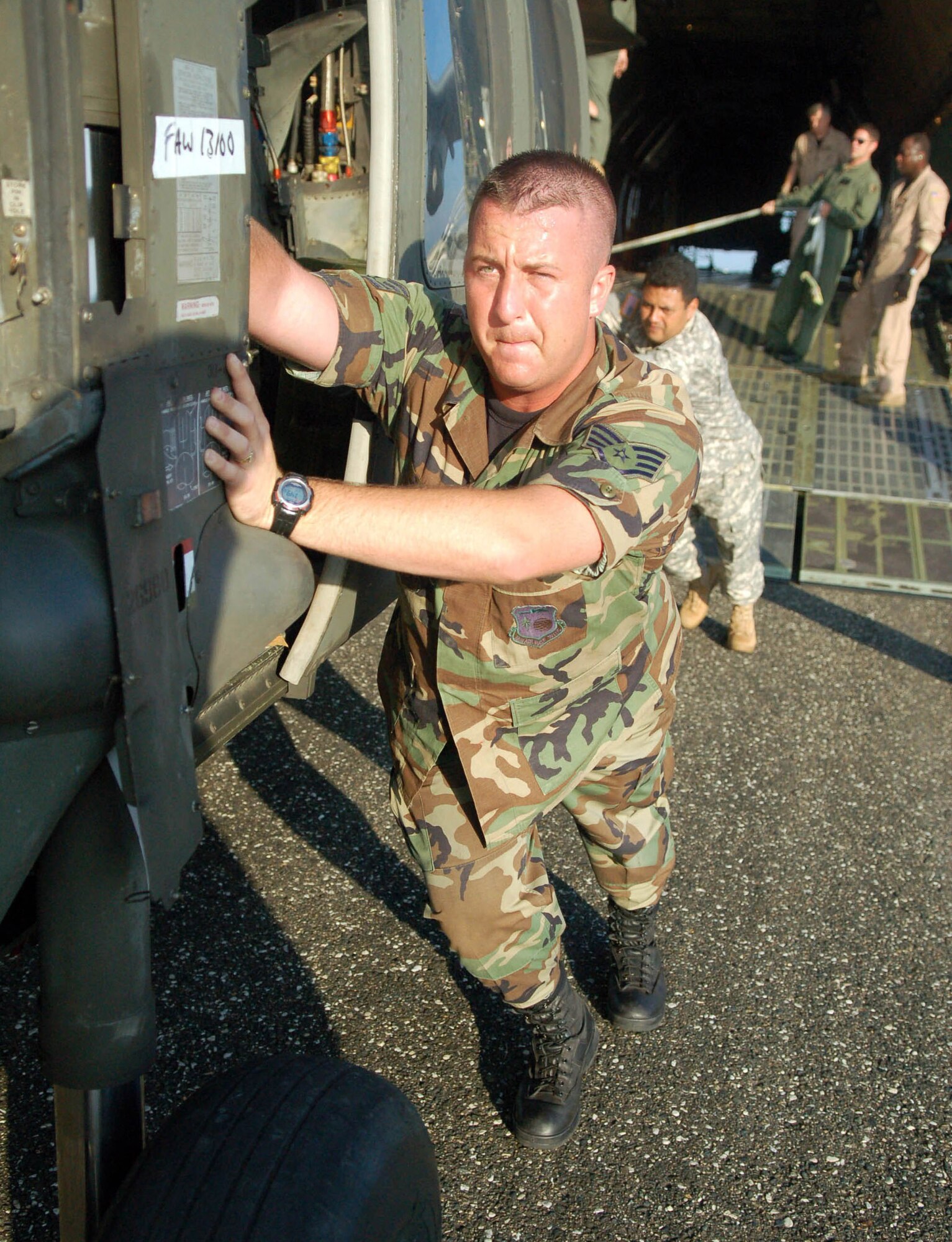 Staff Sgt David Pagani helps push an Army UH-60 Blackhawk helicopter out of a C-5 Galaxy Nov. 8 at  San Isidro Air Base, Dominican Republic. Servicemembers deployed from Joint Task Force-Bravo at Soto Cano Air Base, Honduras, to assist the Dominican Republic after it was ravaged by Tropical Storm Noel are now refocusing efforts  from search and rescue to helping the sick and injured. (U.S. Air Force photo by Staff Sgt. Austin M. May) 