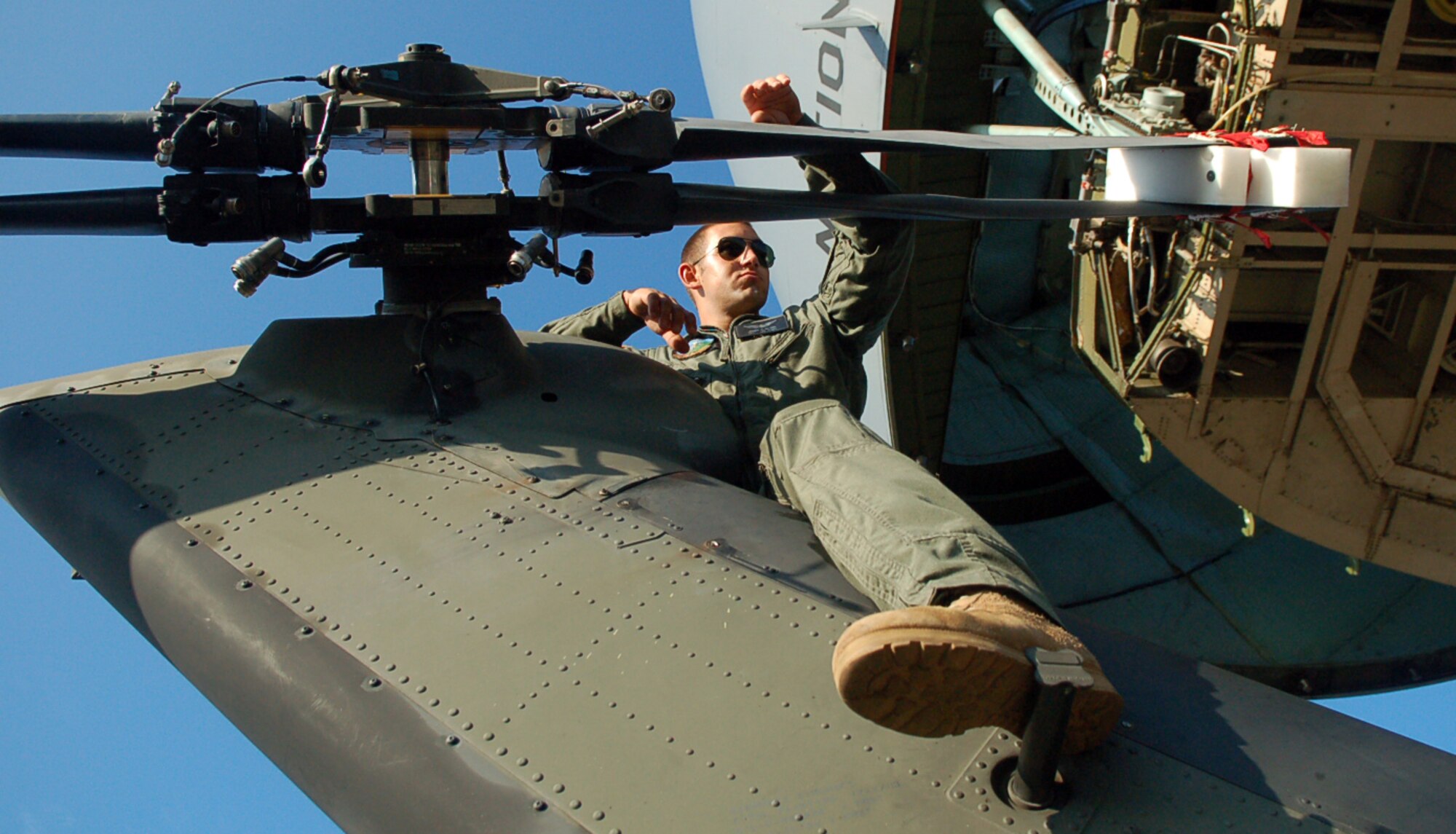 Army Spc. James Bilton rides the tail of an Army UH-60 Blackhawk helicopter to ensure it is safely removed from an C-5 Galaxy aircraft at San Isidro Air Base, Dominican Republic, in preparation for medical relief missions. Servicemembers are deployed from Joint Task Force-Bravo at Soto Cano Air Base, Honduras, to assist the Dominican Republic after it was ravaged by Tropical Storm Noel. Specialist Bilton is with the 1st Battalion, 228th Aviation Regimen. (U.S. Air Force photo/Staff Sgt. Austin M. May) 