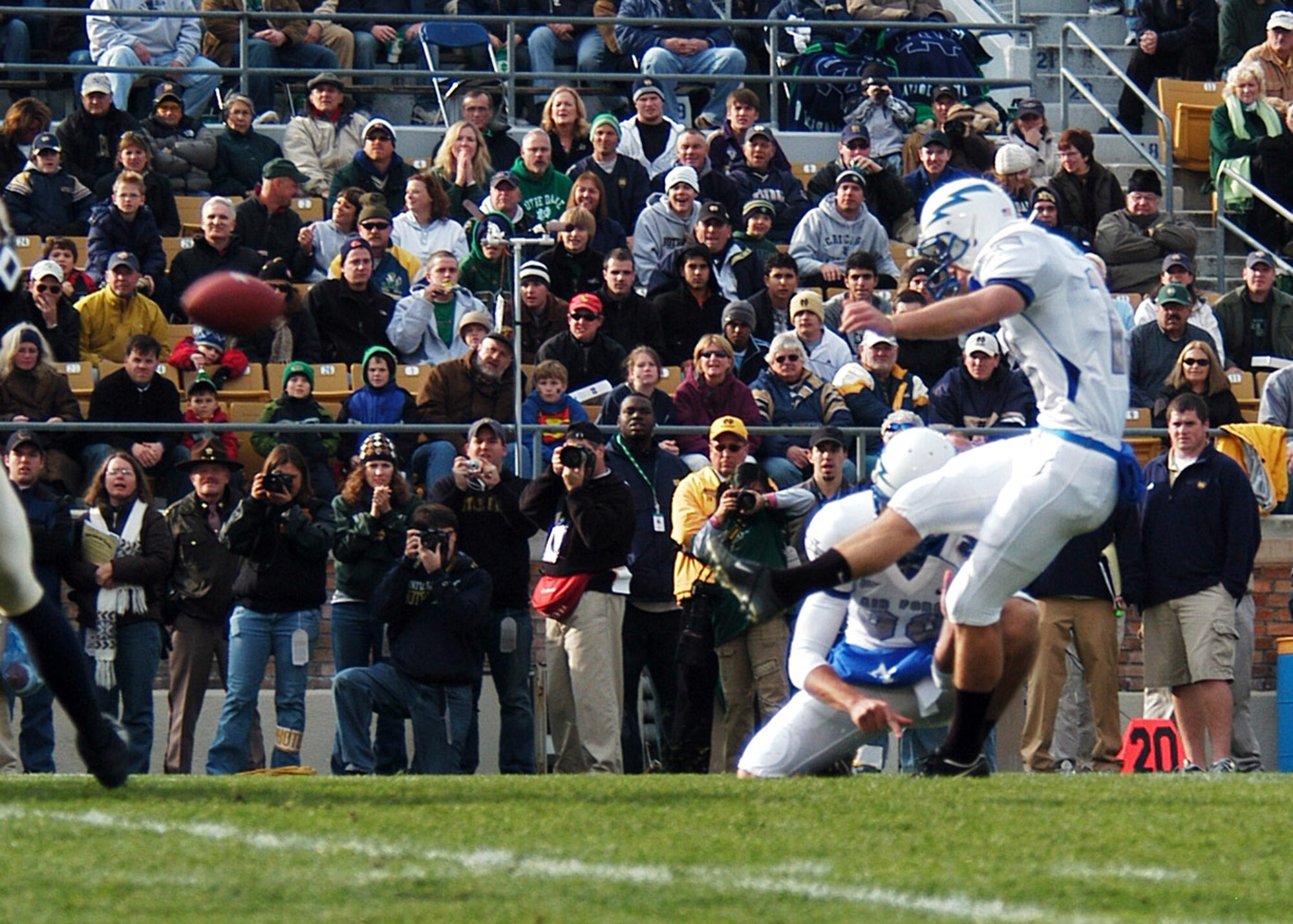 U.S. Air Force Academy Falcon kicker Ryan Harrison boots out of the hold of Brandon Geyer as sideline photographers get the shot during Air Force's 41-24 victory over the Fighting Irish Nov. 10 at Notre Dame Stadium in Indiana. Harrison accounted for 11 points on two field goals and five points after touchdown. (U.S. Air Force photo/Staff Sgt. Monte Volk) 
