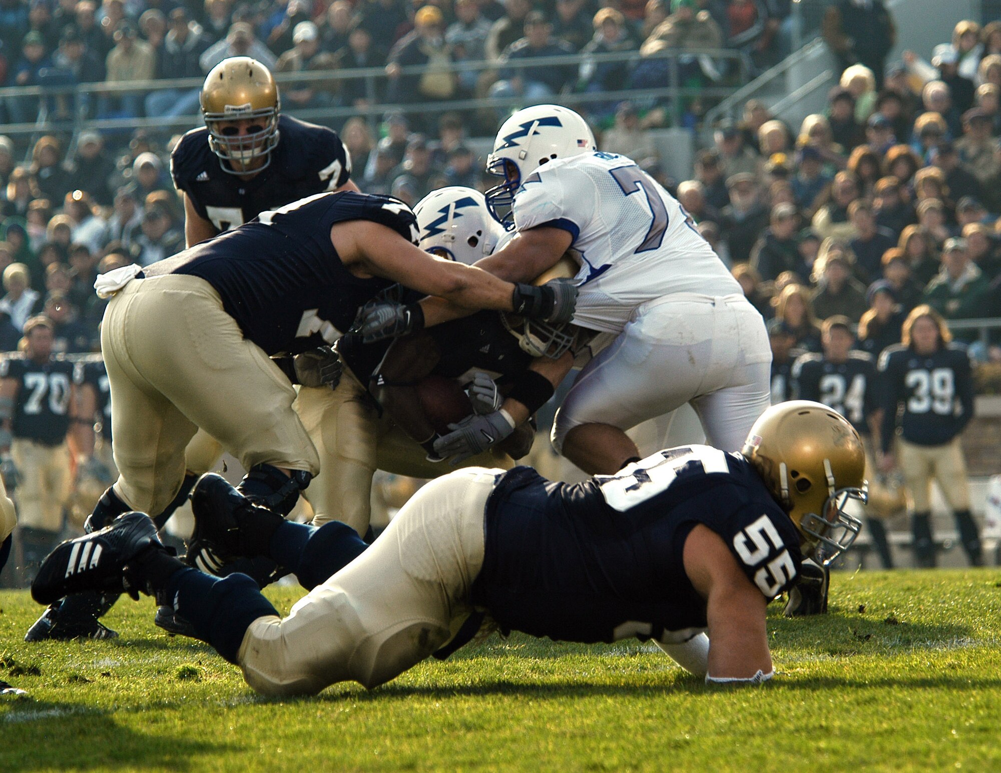 U.S. Air Force Academy Falcon nose guard Stephen Larsen has his jersey grabbed by Fighting Irish offensive lineman Michael Turkovich as Larsen and company swarm around an Irish running back during Air Force's 41-24 win Nov. 10 at Notre Dame Stadium in Indiana. (U.S. Air Force photo/Staff Sgt. Monte Volk) 
