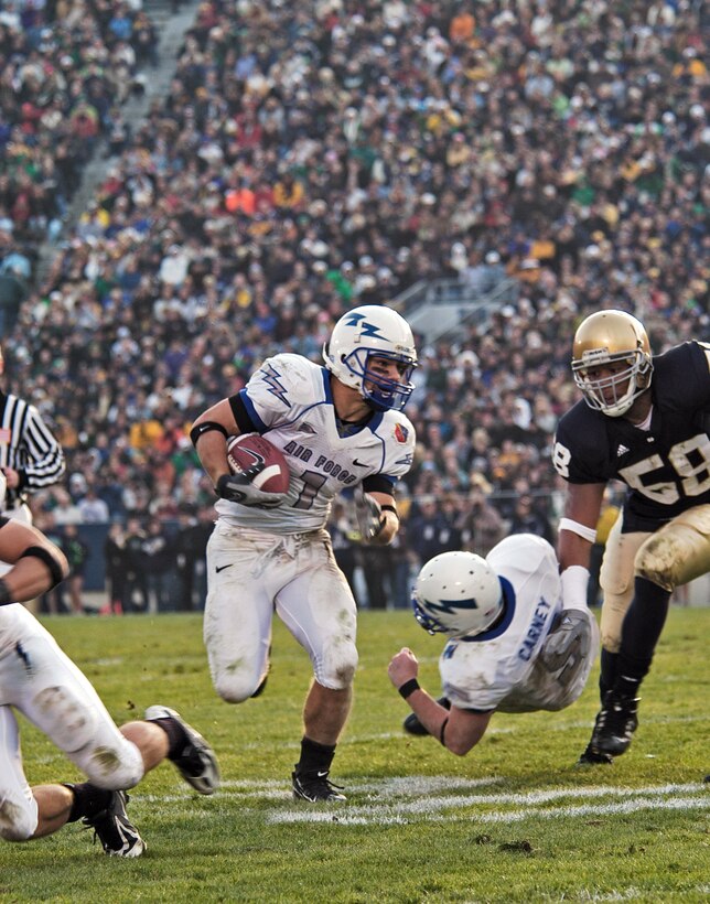 U.S. Air Force Academy Falcon z-back Chad Hall finds running room thanks to a block by quarterback Shaun Carney on Fighting Irish outside linebacker Brian Smith, 58, during Air Force's 41-24 win Nov. 10 at Notre Dame Stadium in Indiana. Hall carried a game-high 32 times for 142 yards, an average of 4.4 yards per carry (U.S. Air Force photo/Staff Sgt. Monte Volk) 