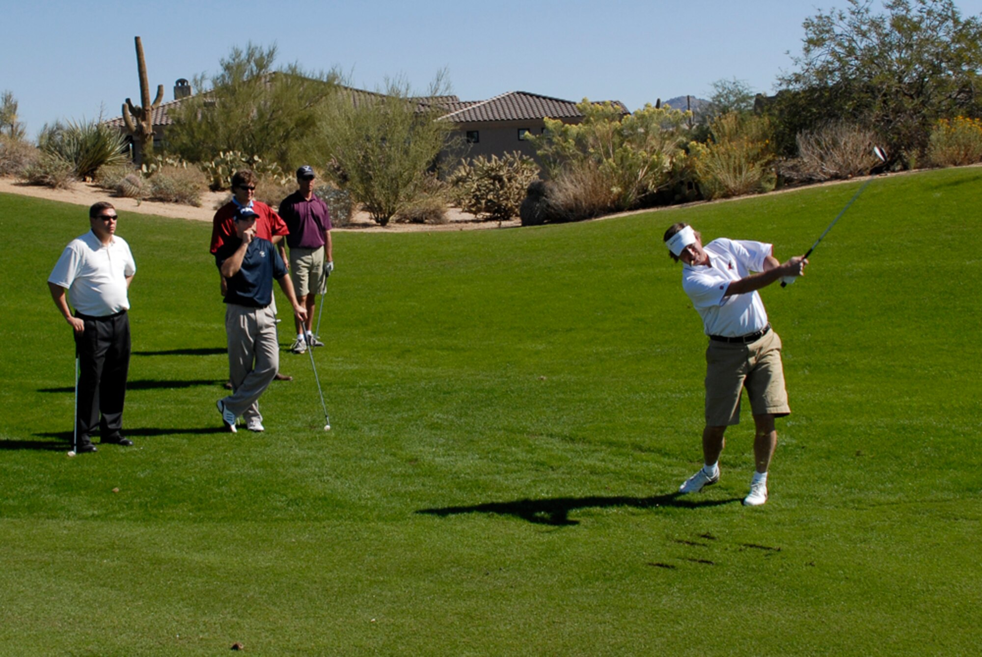 FROM LEFT: Capt. Bruce Ropte, 56th Medical Group; Chief Master Sgt. Bryce Maxson, 56th Communications Squadron; Senior Airman Ross Danaher, 56th Services Squadron; and Staff Sgt. Andrew Tischler, 756th Aircraft Maintenance Squadron, look on as Wayne Gretzky takes a swing during a Phoenix Coyotes charity golf tournament. (photo by Senior Airman Christpher Hummel)