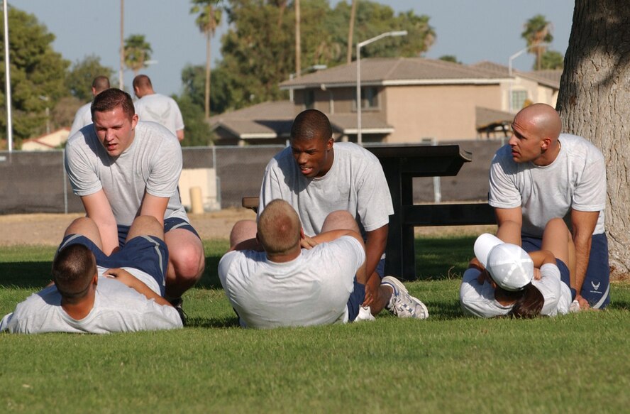 Senior Airmen Leroy Eskey, 56th Aircraft Maintenance Squadron, Carnelle Stradford 56th Aircraft Maintenance Squadron and Constantin Malek, 56th Medical Operations Squadron, assist their partners perform sit ups during the Airman Leadership School “great race.” The race was held at Fowler Park Wednesday. Each flight completed a series of exercises in hopes of winning a fitness competition against the other flights in the school.(photo by Airman 1st Class Tracy Forte)