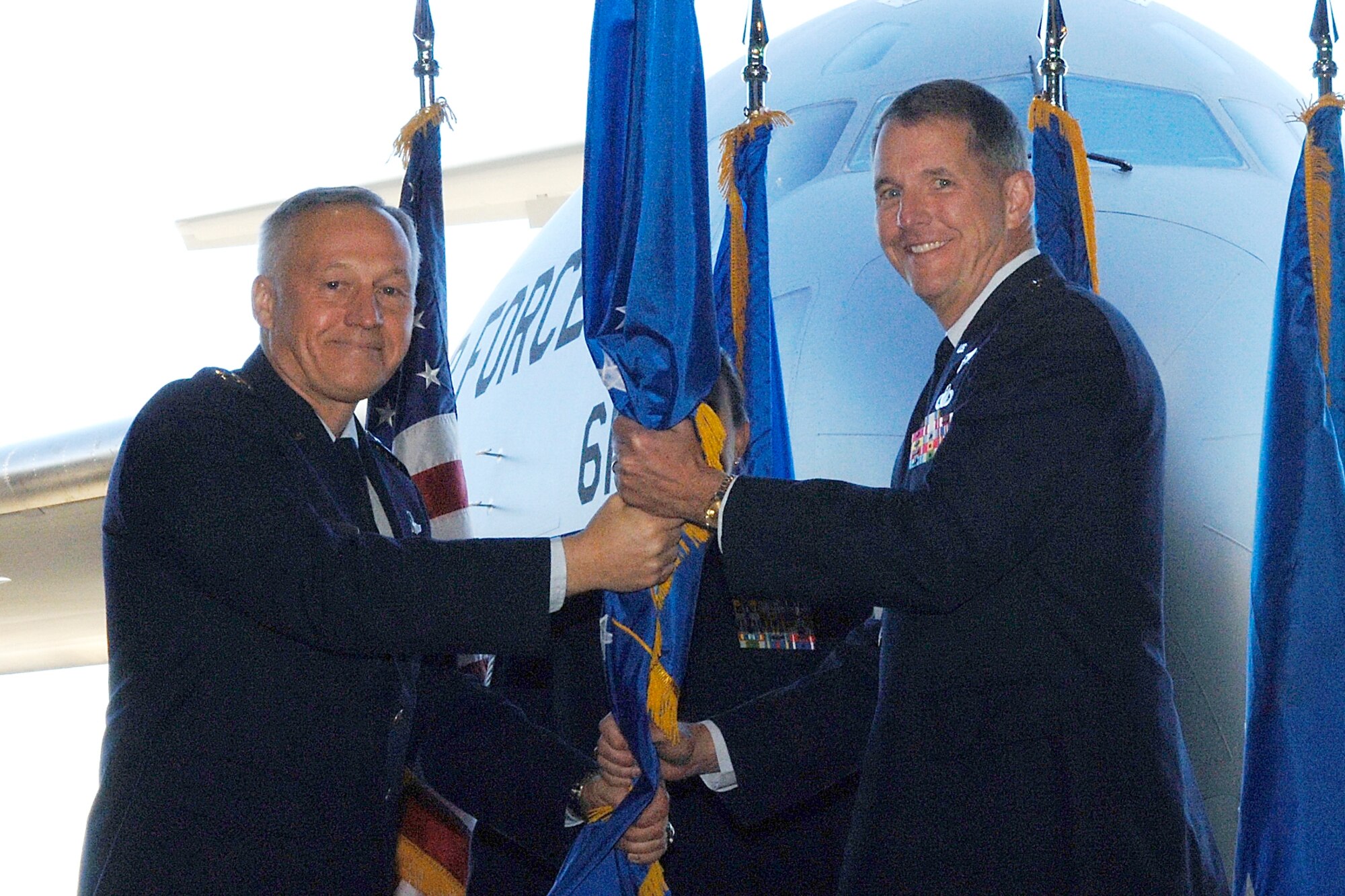 With a C-17 Globemaster parked behind him, Gen. Bruce Carlson, commander of the Air Force Materiel Command, passes the command guidon to Lt. Gen. Ted Bowlds during the Electronic Systems Center Change of Command Ceremony held at Hanscom AFB Nov. 7.  General Bowlds took the reins of command from Lt. Gen. Chuck Johnson, who retired in follow-on ceremony, after more than 35 years of service. (AF photo by Jan Abate)