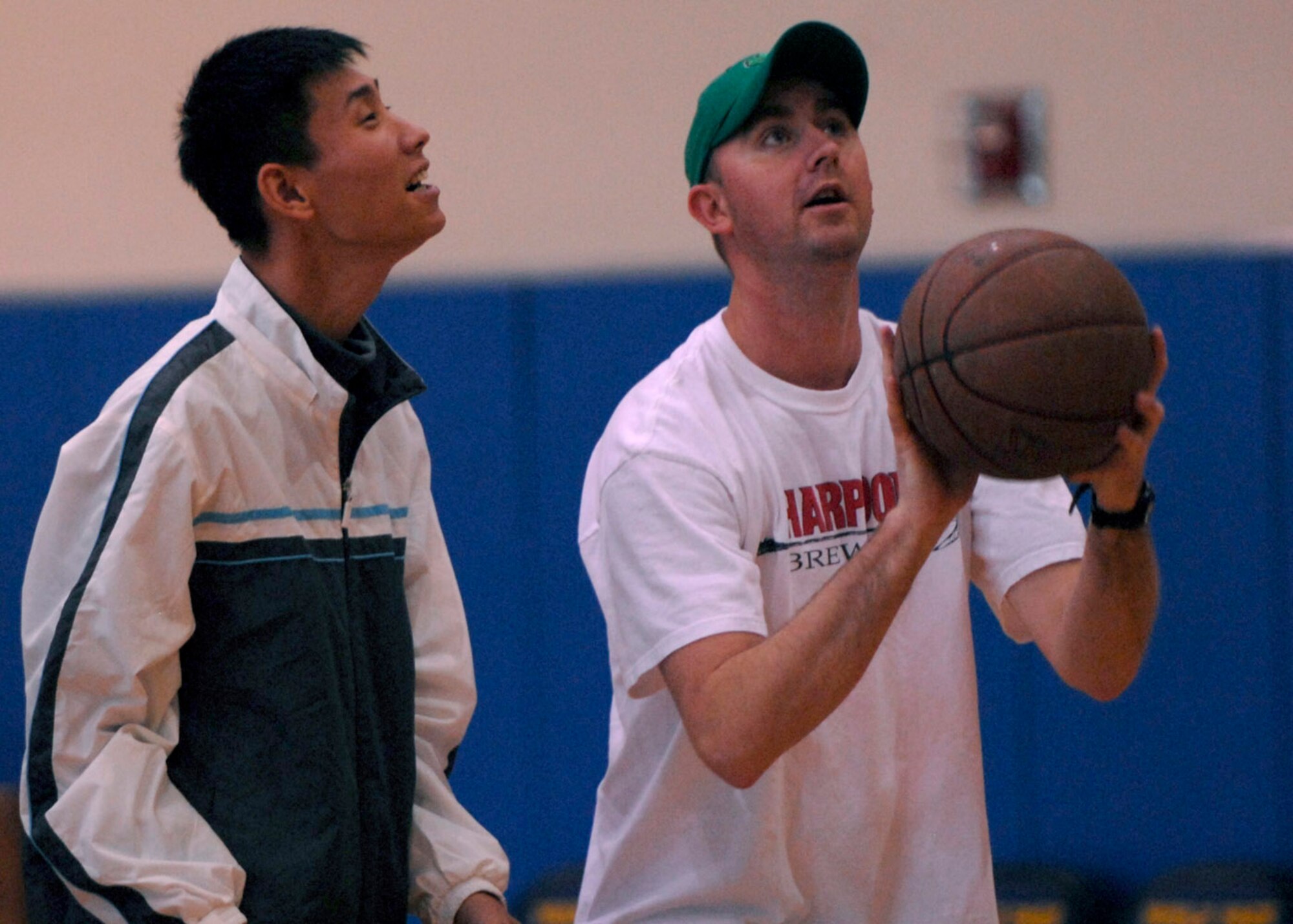 KUNSAN AIR BASE, South Korea— First Lieutenant Bill Chalmers, 8th Medical Group chief of laboratory services, teaches a young man how to shoot a basket at the fitness center here Nov 10. The Good Neighbor Program is designed for the base to actively engage with the local community to strengthen ties (U.S. Air Force photo/Staff Sgt. Araceli Alarcon)