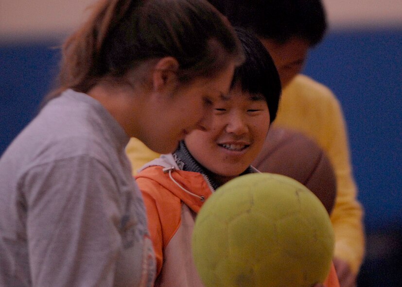 KUNSAN AIR BASE, South Korea—  Senior Airman Lindsay DeReadt, 8th Communications Squadron military postal clerk, interacts with a young girl at the fitness center here Nov 10. The Good Neighbor Program is designed for the base to actively engage with the local community to strengthen ties. 
(U.S. Air Force photo/Staff Sgt. Araceli Alarcon)
