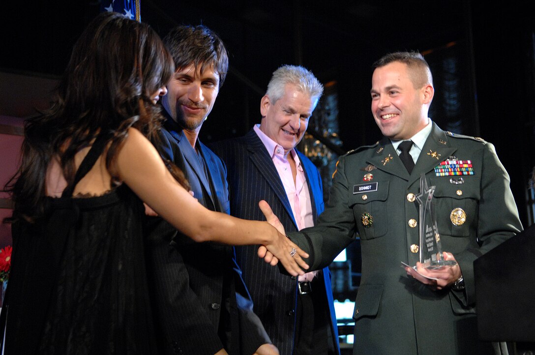 Cast members from the FX show "Rescue Me" congratulate U.S. Army Maj. Todd Schmidt during the Microsoft Above and Beyond Awards Ceremony Nov. 12, 2007, in New York. Schmidt, a member of the headquarters Army staff at the Pentagon in Washington, D.C., received the award for providing school supplies for children in Afghanistan.