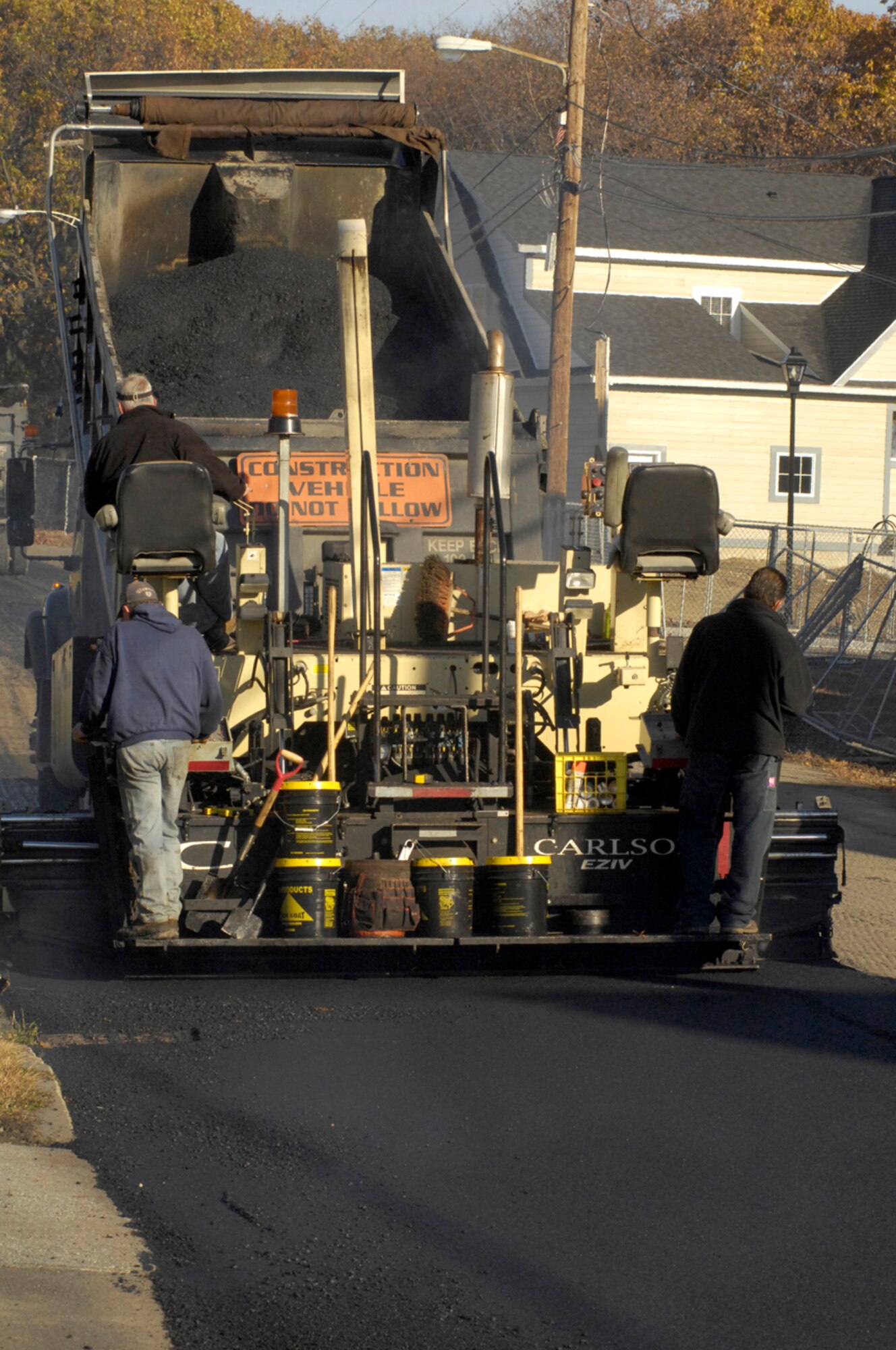 HANSCOM AFB, Mass. -- Contractors pave the road leading to the Old Musket Meadows neighborhood on Nov. 14. The road had been graded and scarified in June before construction on Hanscom’s privatized housing came to a halt. A coordinated effort on the part of the Air Force Center for Engineering and the Environment, Air Force Materiel Command Headquarters and the Hanscom Civil Engineer team resulted in the road being paved before winter. (U.S. Air Force photo by Mark Wyatt)
 
