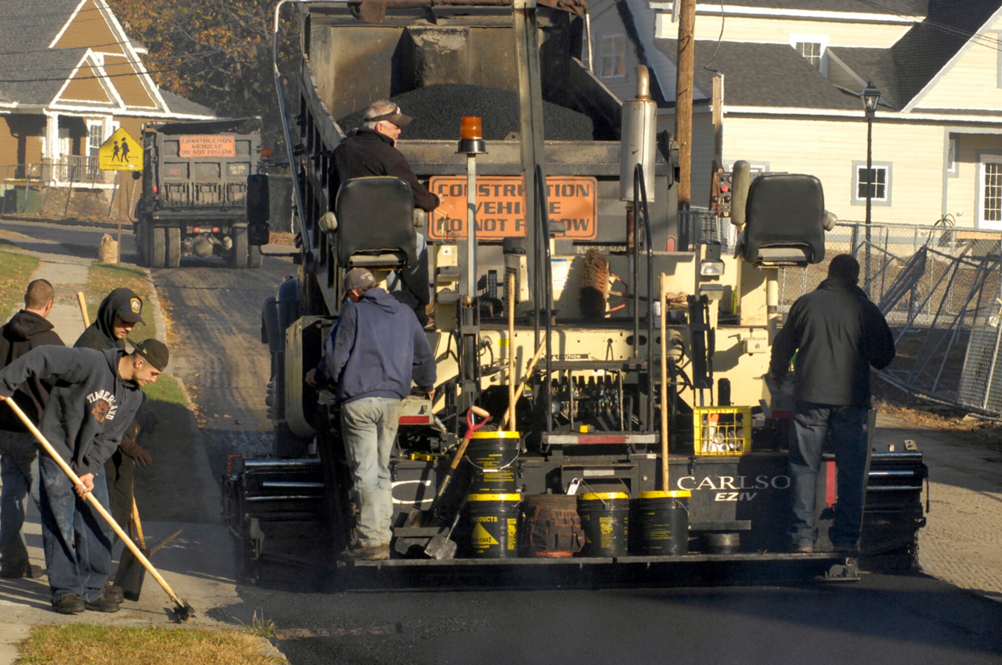 HANSCOM AFB, Mass. -- Contractors pave the road leading to the Old Musket Meadows neighborhood on Nov. 14. The road had been graded and scarified in June before construction on Hanscom’s privatized housing came to a halt. A coordinated effort on the part of the Air Force Center for Engineering and the Environment, Air Force Materiel Command Headquarters and the Hanscom Civil Engineer team resulted in the road being paved before winter. (U.S. Air Force photo by Mark Wyatt)
 
