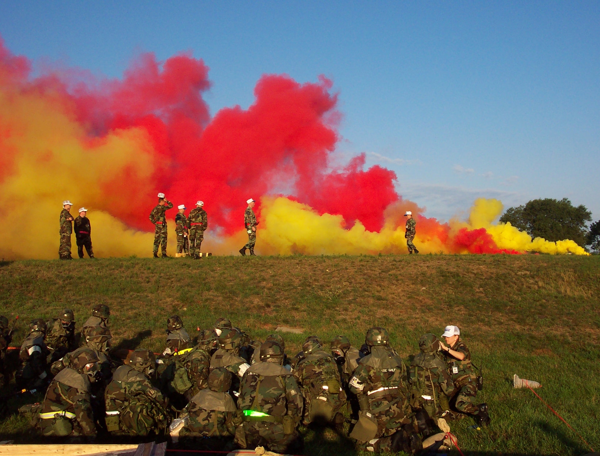 As smoke canisters explode, members of the 85th Aerial Port Squadron take cover at Volk Field, Wisc., during a practice for the unit's upcoming Operational Readiness Inspection. The 85th APS is the 439th Airlift Wing's geographically separated unit located at Hanscom Air Force Base, Mass. (US Air Force photo/Capt. Rebecca Boothby)