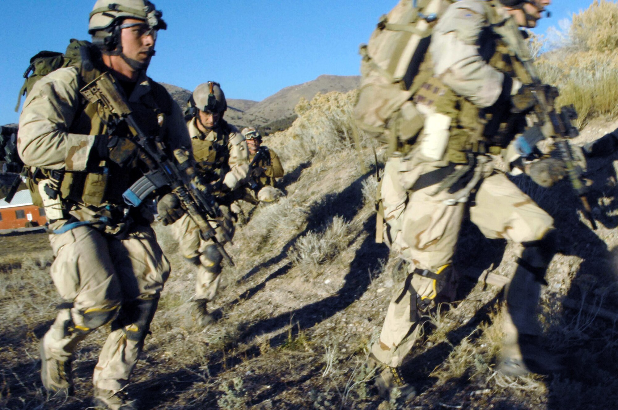 Pararescuemen make an urban village assault during an extraction of a simulated downed pilot during a combat search and rescue integration exercise Nov. 8 at Camp Williams, Utah. The pararescuemen are from the 58th Rescue Squadron, Nellis Air Force Base, Nev. Members of the 34th Weapons Squadron from Nellis AFB led the search and recovery training. The exercise expanded the integration with Utah's 211th Aviation Group AH-64 Apache Joint Rotary Wing, 4th Fighter Squadron F-16 Fighting Falcon assets from Hill AFB, Utah, and special operations forces. Exercise participants also conducted extensive joint combat search and rescue operations against surface-to-air threats. The exercise is being run held Nov. 6 through 15. (U.S. Air Force photo/Master Sgt. Kevin J. Gruenwald) 
