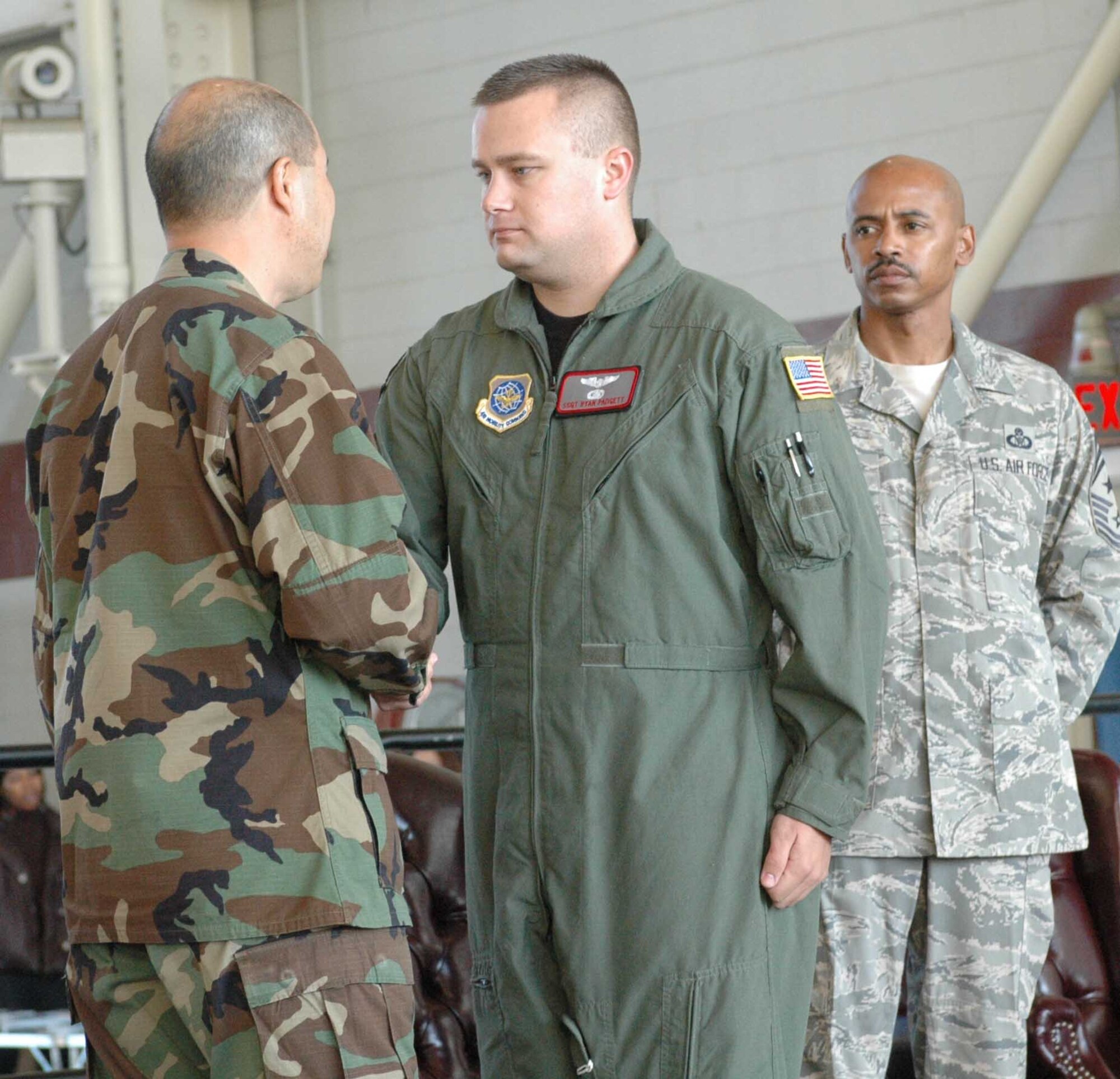 Col. GI Tuck, 60th Air Mobility Wing vice commander, presents Staff Sgt. Ryan Padgett, 22nd Airlift Squadron, with a coin during Wingman Day Nov. 9. Colonel Tuck briefed Team Travis members about the importance of taking care of and getting to know your fellow wingman. (U.S. Air Force photo/Staff Sgt. Candy Knight)