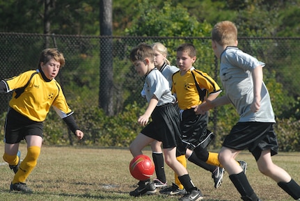 Jacob LeCroy, 9, son of Tech. Sgt. William LeCroy, and Tyler Eisert, 9, son of Staff Sgt. Jay Eisert, try to get the soccer ball past defender Jason Brule, 10, of the Hanahan Kickers during the 9-10-year-old playoff games Saturday on Charleston AFB.  (U.S. Air Force photo/Tech. Sgt. Paul Kilgallon)