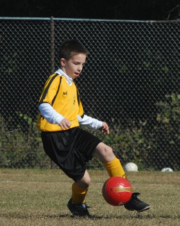 Anthony Benware, 9, of the Hanahan Kickers, works the ball past two Charleston Globemaster team members during the 9-10-year-old playoff games Saturday on Charleston AFB. (U.S. Air Force photo/Tech. Sgt. Paul Kilgallon)