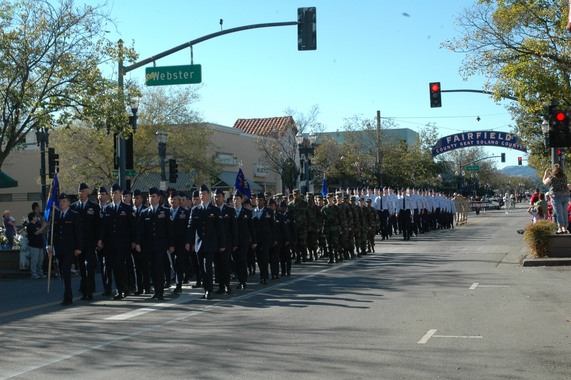 As the crowd cheers, four flights of Airmen from Travis march down North Texas St. during the 7th Annual City of Fairfield Veterans Day Parade Nov. 11. Members of the 60th Air Mobility Wing, 349th Air Mobility Wing, 615th Contingency Response Wing and the base Honor Guard joined the City of Fairfield to honor military veterans. (U.S. Air Force photo/Senior Airman Shaun Emery)