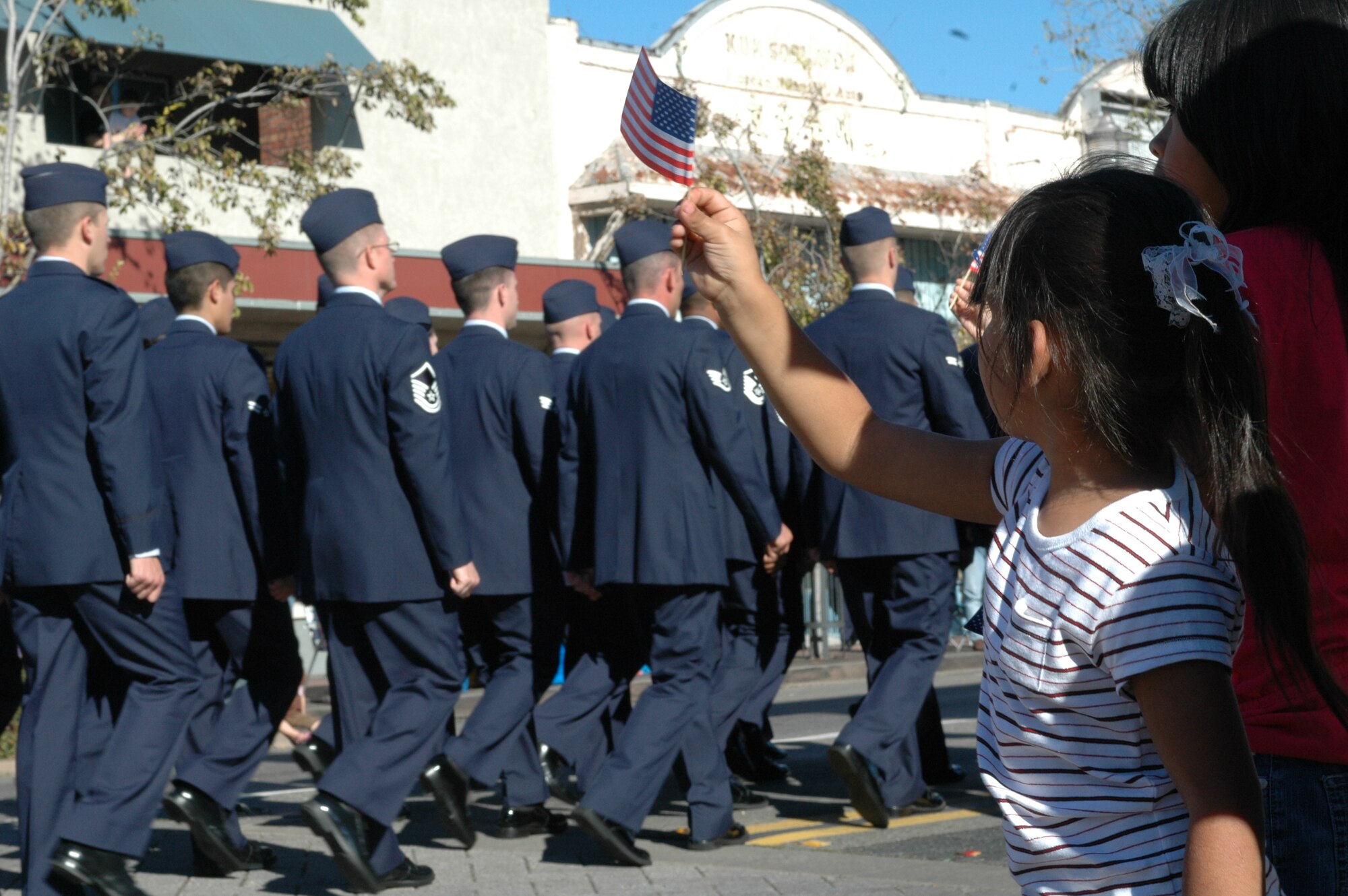 A young girl waves an American Flag as members of Travis march down North Texas St. during the 7th Annual City of Fairfield Veterans Day Parade Nov. 11. (U.S. Air Force photo/Senior Airman Shaun Emery)