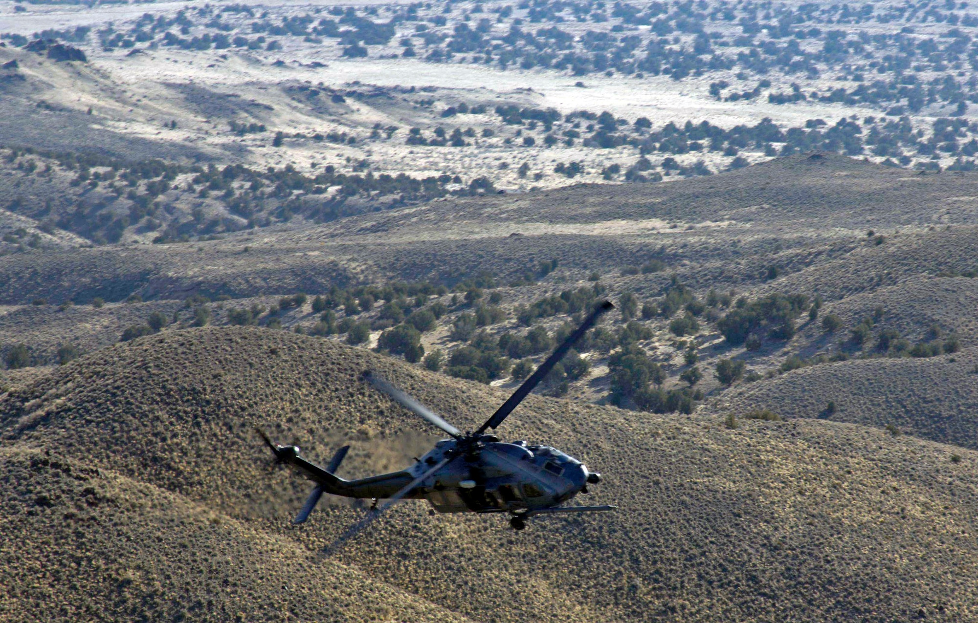 An HH-60 Pave Hawk manuevers over the Utah Test and Training Range during a combat search and rescue integration exercise Nov. 8 in Utah. The HH-60 is from Nellis Air Force Base, Nev. Members of the 34th Weapons Squadron from Nellis AFB led the search and recovery training. The exercise expanded the integration with Utah's 211th Aviation Group AH-64 Apache Joint Rotary Wing, 4th Fighter Squadron F-16 Fighting Falcon assets from Hill AFB, Utah, and special operations forces. Exercise participants also conducted extensive joint combat search and rescue operations against surface-to-air threats. The exercise is being run held Nov. 6 through 15. (U.S. Air Force photo/Master Sgt. Kevin J. Gruenwald) 
