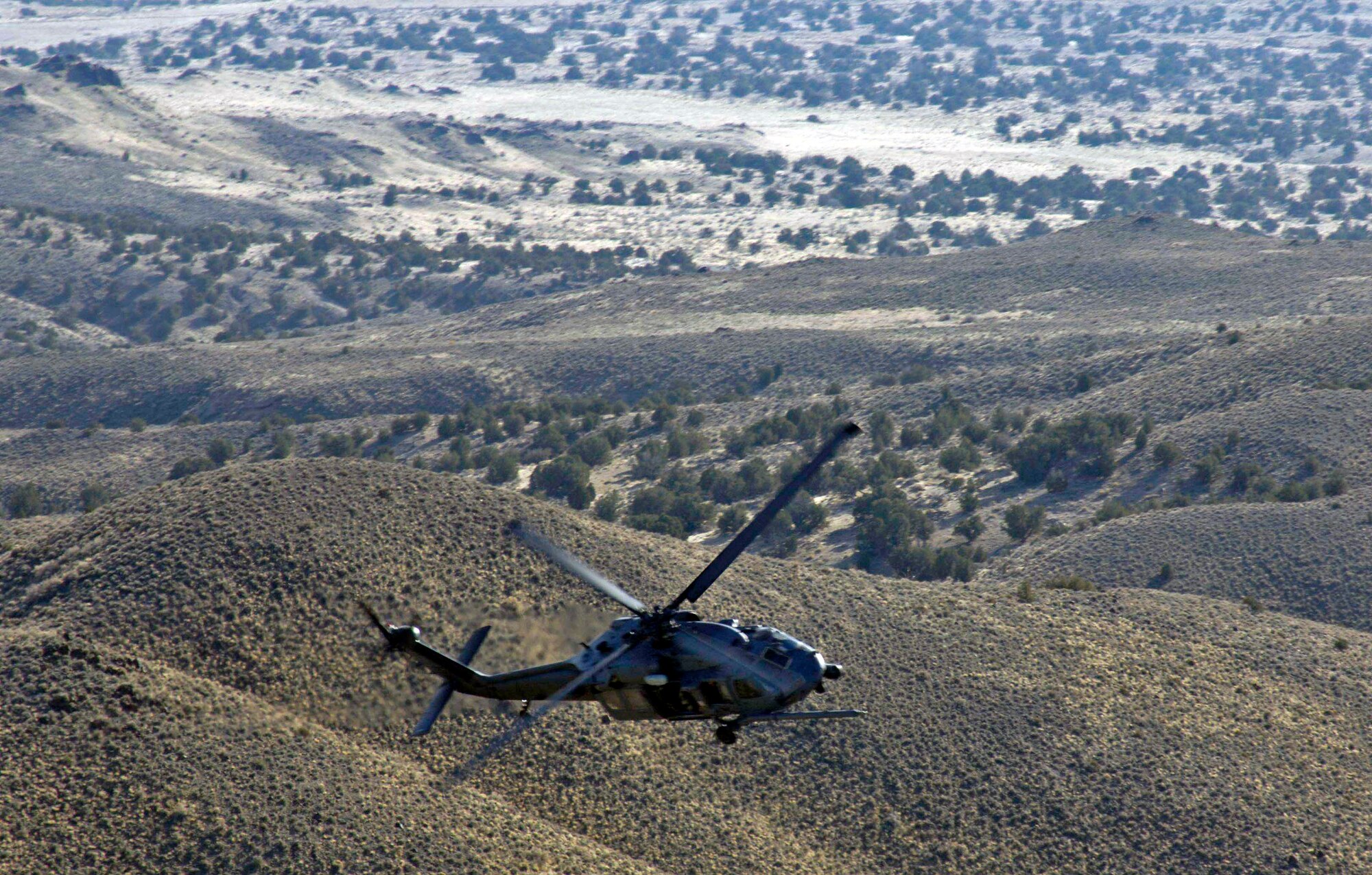 An HH-60 Pave Hawk manuevers over the Utah Test and Training Range during a combat search and rescue integration exercise Nov. 8 in Utah. The HH-60 is from Nellis Air Force Base, Nev. Members of the 34th Weapons Squadron from Nellis AFB led the search and recovery training. The exercise expanded the integration with Utah's 211th Aviation Group AH-64 Apache Joint Rotary Wing, 4th Fighter Squadron F-16 Fighting Falcon assets from Hill AFB, Utah, and special operations forces. Exercise participants also conducted extensive joint combat search and rescue operations against surface-to-air threats. The exercise is being run held Nov. 6 through 15. (U.S. Air Force photo/Master Sgt. Kevin J. Gruenwald) 
