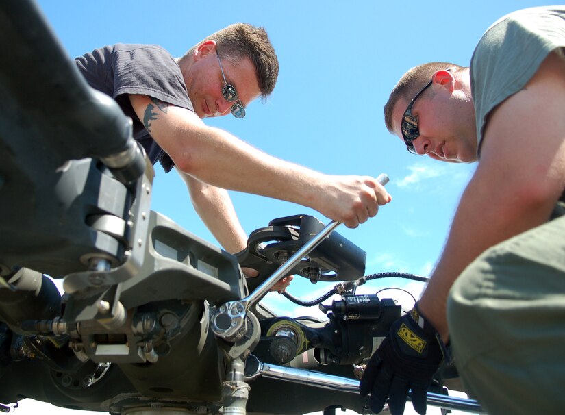 SAN ISIDRO AIR BASE, Dominican Republic -- Air Force Staff Sgt. Robert Daly (left), Joint Task Force-Bravo Medical Element, lends a hand to Army Sgt. 1st Class Jason Rittichier, a UH-60 crew chief with the 1st Battalion-228th Aviation Regiment, while he secures the main rotor blades on a Black Hawk that has just been unloaded from an Air Force C-5 Galaxy in the Dominican Republic.  JTF-Bravo deployed a team of 21 servicemembers to assist in relief efforts after Tropical Storm Noel pounded the small island nation.  (U.S. Air Force photo by Staff Sgt. Austin M. May)