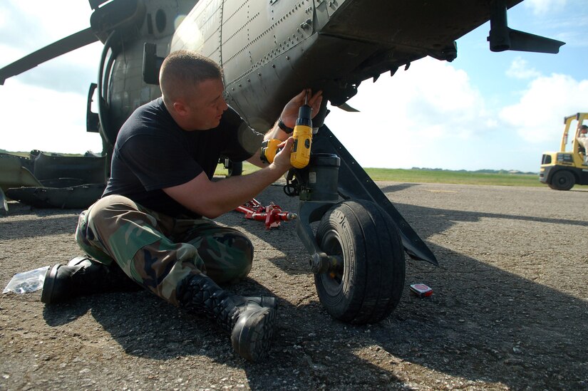 SAN ISIDRO AIR BASE, Dominican Republic -- Air Force Staff Sgt. David Pagani, Joint Task Force-Bravo Medical Element, screws panels onto an Army UH-60 Black Hawk helicopter during a disaster relief mission to the Dominican Republic.  JTF-Bravo deployed a team of 21 servicemembers to assist in relief efforts after Tropical Storm Noel pounded the small island nation.  (U.S. Air Force photo by Staff Sgt. Austin M. May)