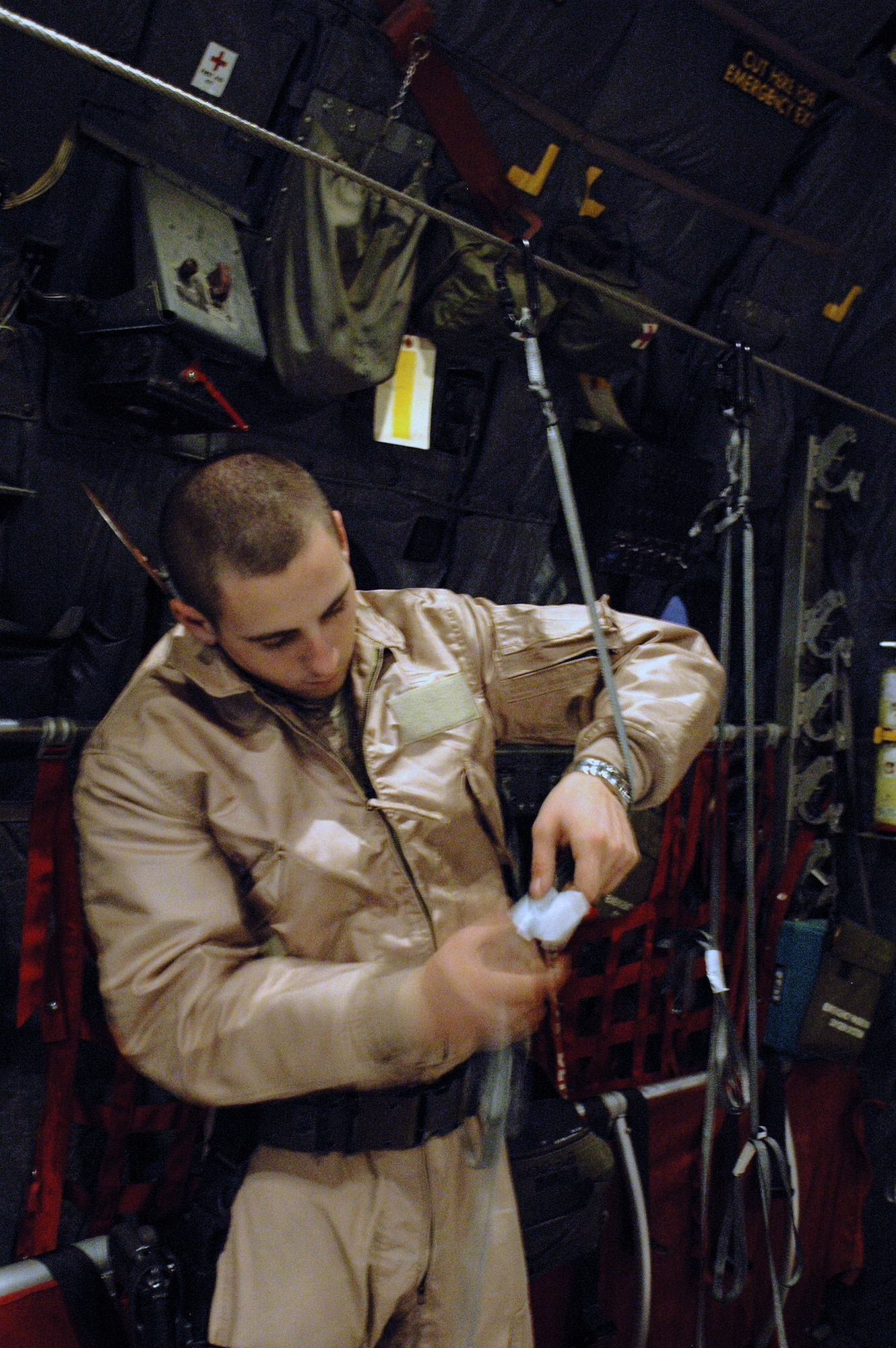 Senior Airman William Moody sets up static lines on board a C-130 Hercules to help rip open boxes of leaflets in October in Southwest Asia. The aircraft crew dropped 300,000 leaflets over an area of Afghanistan. Airman Moody is a 40th Expeditionary Airlift Squadron loadmaster. (U.S. Air Force photo/Staff Sgt. Jason Barebo) 

