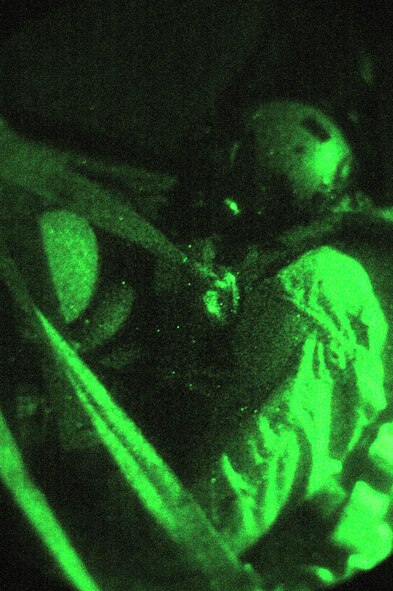 Tech. Sgt. Kevin Letz watches through a C-130 Hercules window during a leaflet drop mission in October over Afghanistan. Sergeant Letz watches for enemy activity using night-vision goggles to ensure the safety of the crew and aircraft from possible enemy attack. Sergeant Letz, a 40th Expeditionary Airlift Squadron loadmaster is deployed from Dyess Air Force Base, Texas. (U.S. Air Force photo/Staff Sgt. Jason Barebo) 