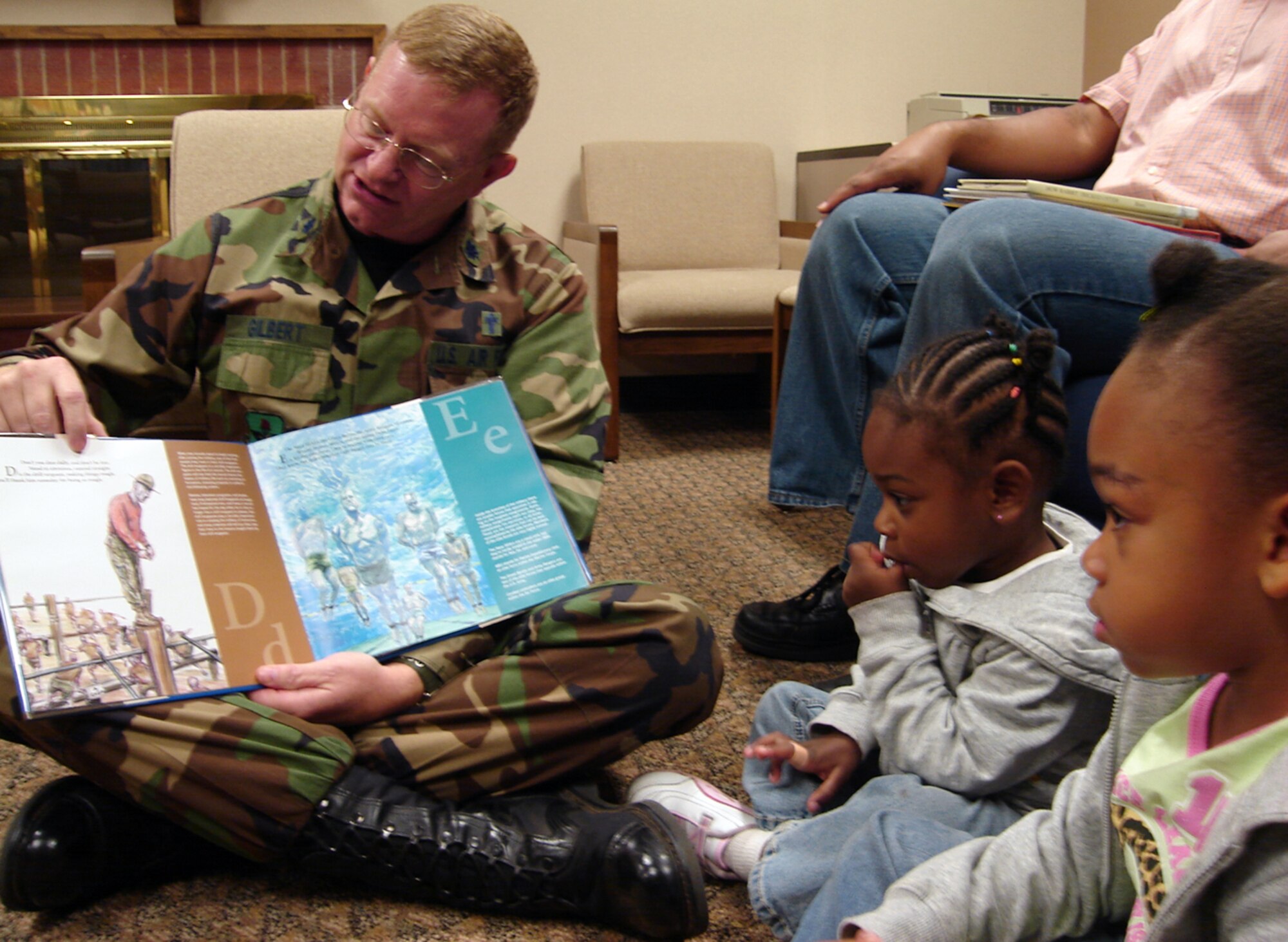 Chaplain (Lt Col) Mike Gilbert, wing chaplain, reads a story to Juliana, 4, and Elyse, 2, daughters of Staff Sgt. Nina and Marico Sellers during Family Night sponsored by the base library and the Airman and Family Readiness Center Nov. 13. Team Vance members read military and American-Indian Heritage-themed books to celebrate Military Family Month.  (U.S. Air Force photo by Tech. Sgt. Mary Davis)