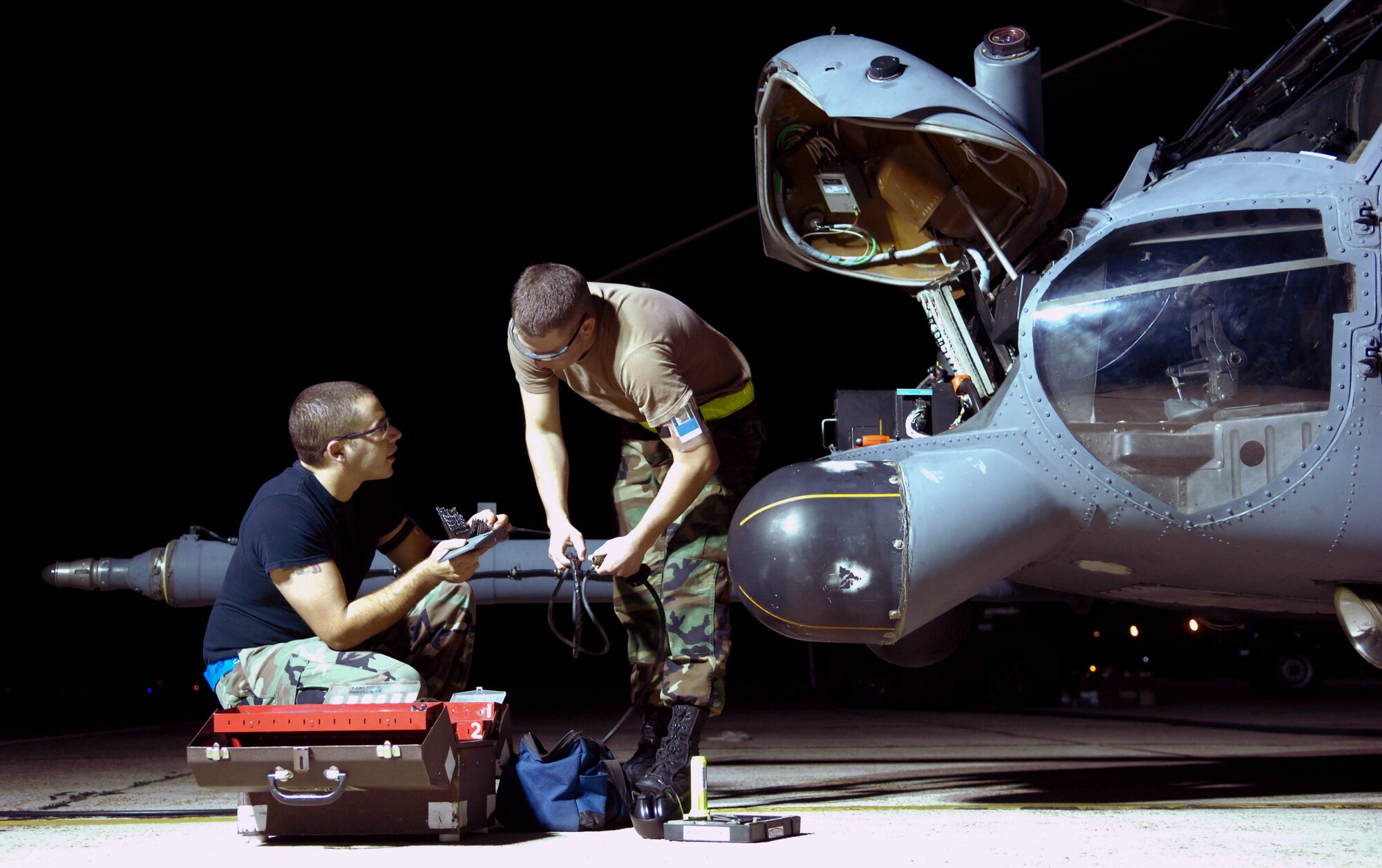Senior Airman John Baia and Airman 1st Class Eric Dininger work on an HH-60G Pave Hawk helicopter Oct. 31 at Moody Air Force Base, Ga. Moody AFB Airmen work around the clock to ensure flight success of the aircraft. Airmen Baia and Diniger are assigned to the 23rd Equipment Maintenance Squadron. (U.S. Air Force photo/Senior Airman Elizabeth Rissmiller) 
