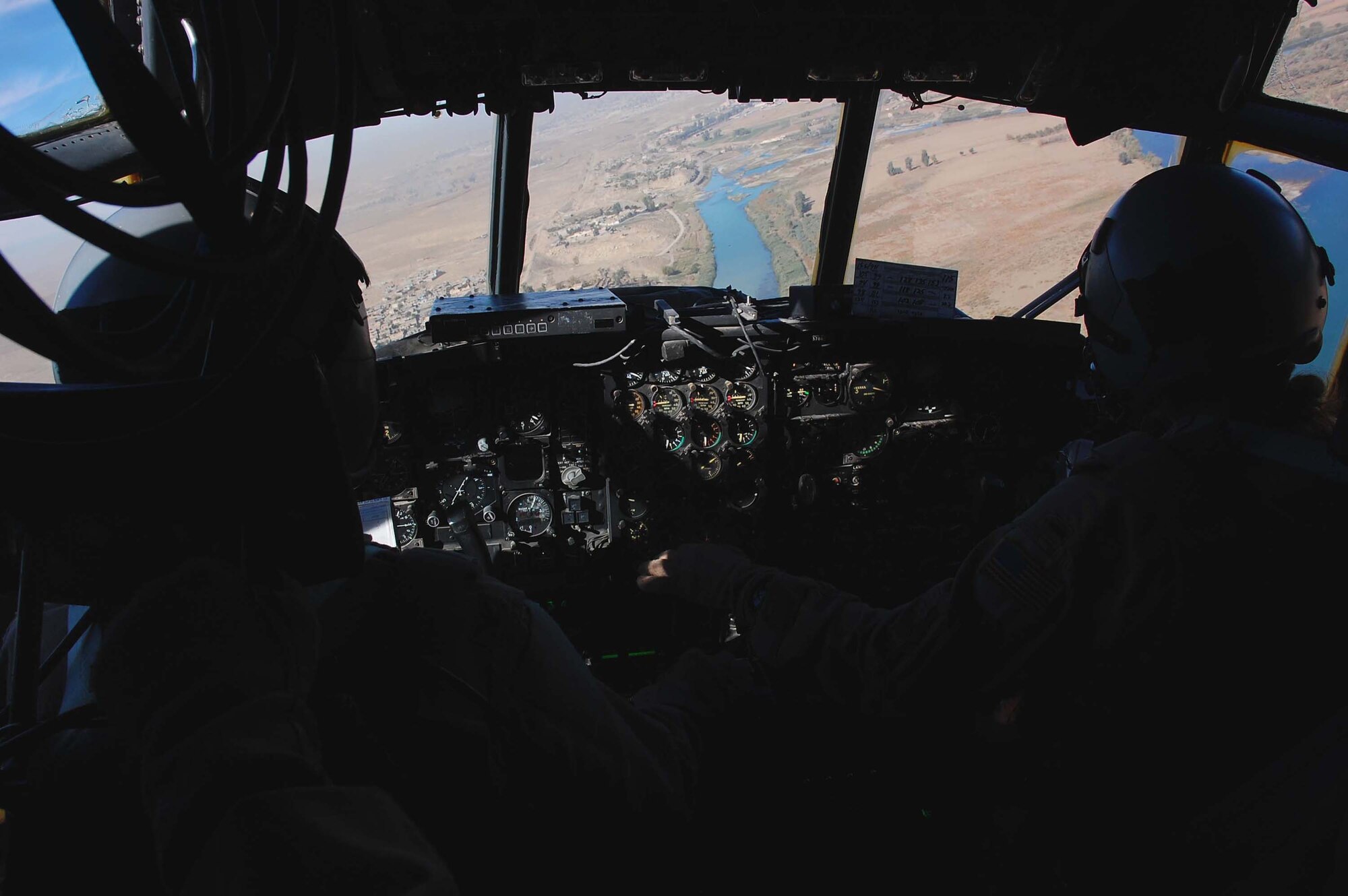 SOUTHWEST ASIA -- Col. Brian O'Connor (left), 386th Air Expeditionary Wing vice commander, and 1st Lt. Justine Perlbert, 737th Expeditionary Aircraft Squadron co-pilot, fly C-130 aircraft, tail number 63-7865, near Mosul, Iraq, Nov. 13. The aircraft had just flown its last combat mission and will be flown to Davis-Monthan AFB, Ariz., where it will be laid to rest at the "boneyard." The C-130 became an honorary purple heart recipient in June of 1972 for damages sustained from mortar fire in Vietnam.  (U.S. Air Force photo/Staff Sgt. Tia Schroeder)