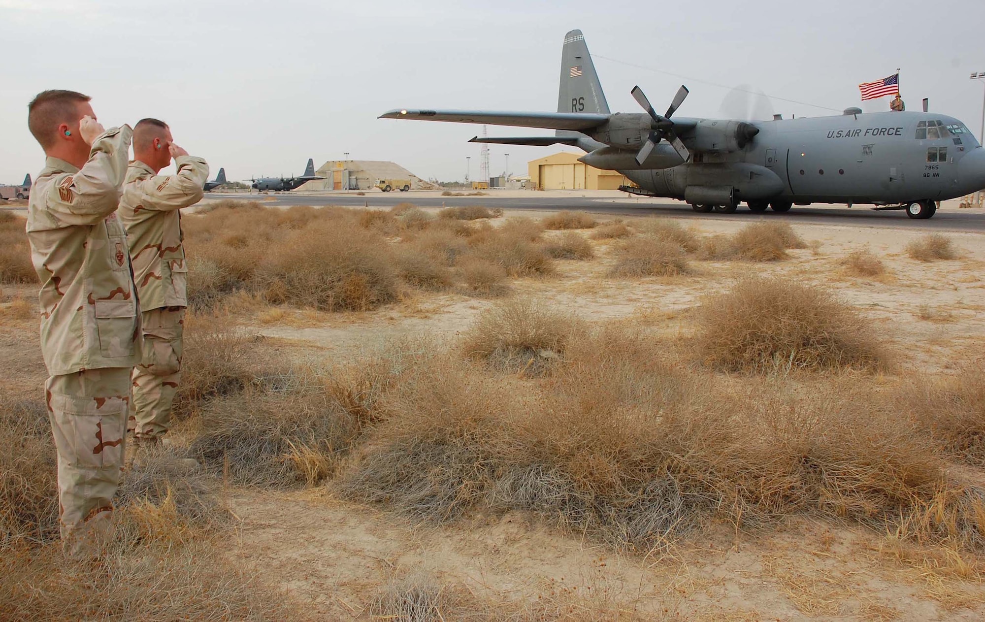 SOUTHWEST ASIA -- Airmen from the 386th Air Expeditionary Wing proudly render a final salute to C-130 aircraft, tail number 63-7865, from Ramstein AB, Germany, at an undisclosed location in Southwest Asia Nov. 13. The aircraft had just flown its last combat mission and will be flown to Davis-Monthan AFB, Ariz., where it will be laid to rest at the "boneyard." The C-130 became an honorary purple heart recipient in June of 1972 for damages sustained from mortar fire in Vietnam.  (U.S. Air Force photo/Staff Sgt. Tia Schroeder)