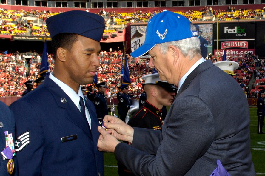 (right to left) Secretary of the Air Force Michael W. Wynne ceremoniously pins a Purple Heart on Staff Sgt. Huey Harris, 436th Services Squadron, during the half-time ceremony at the Washington Redskins versus Philadelphia Eagles NFL game Nov. 11. Sergeant Harris was injured during a convoy movement while deployed to Kandahar, Afghanistan. (U.S. Air Force photo by Senior Airman Dan DeCook)