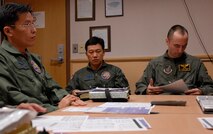KUNSAN AIR BASE, South Korea--  Capt. Yim, Chang-soon weapons officer and Maj. Park, Dae-seo, director of operations from the 111th Fighter Squadron and Capt. Christopher Jones, 80th Fighter Squadron pilot, prepares for a flight mission brief here Nov. 14. ROKAF pilots and Wolf Pack pilots trained together on a joint mission to give pilots from both countries a chance to work together and hone their war-fighting skills.  (U.S. Air Force Photo/Staff Sgt. Araceli Alarcon) 