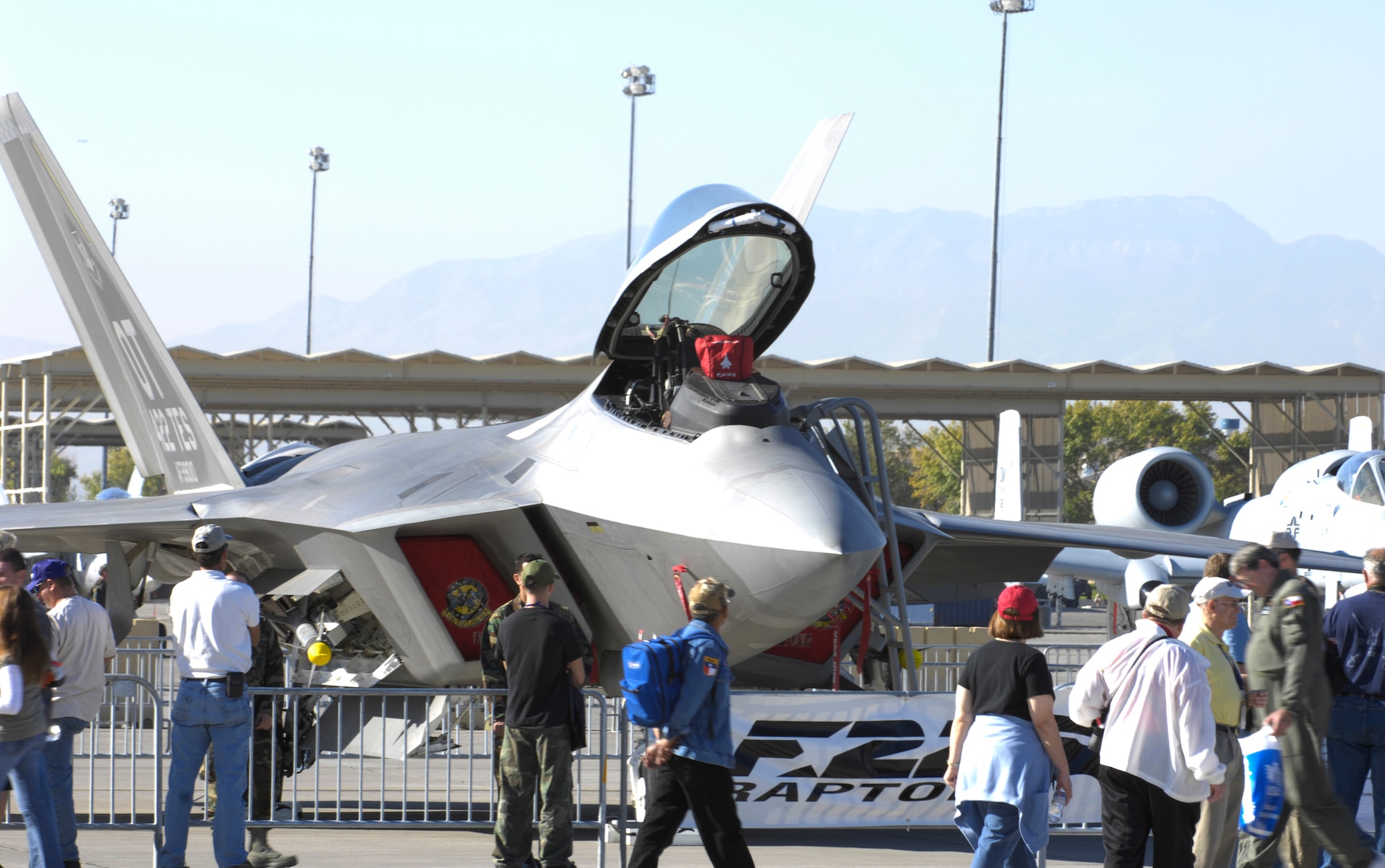 NELLIS AIR FORCE BASE, Nev. -- Visitors stop to look at the F-22 Raptor during the 60th Anniversary Air Show here on Nov. 10. The Raptor is an air superiority fighter that uses stealth technology, but is also equipped for ground attack, electronic warfare and signals intelligence roles as well. (U.S. Air Force photo/Airman 1st Class Matthew Plew)
