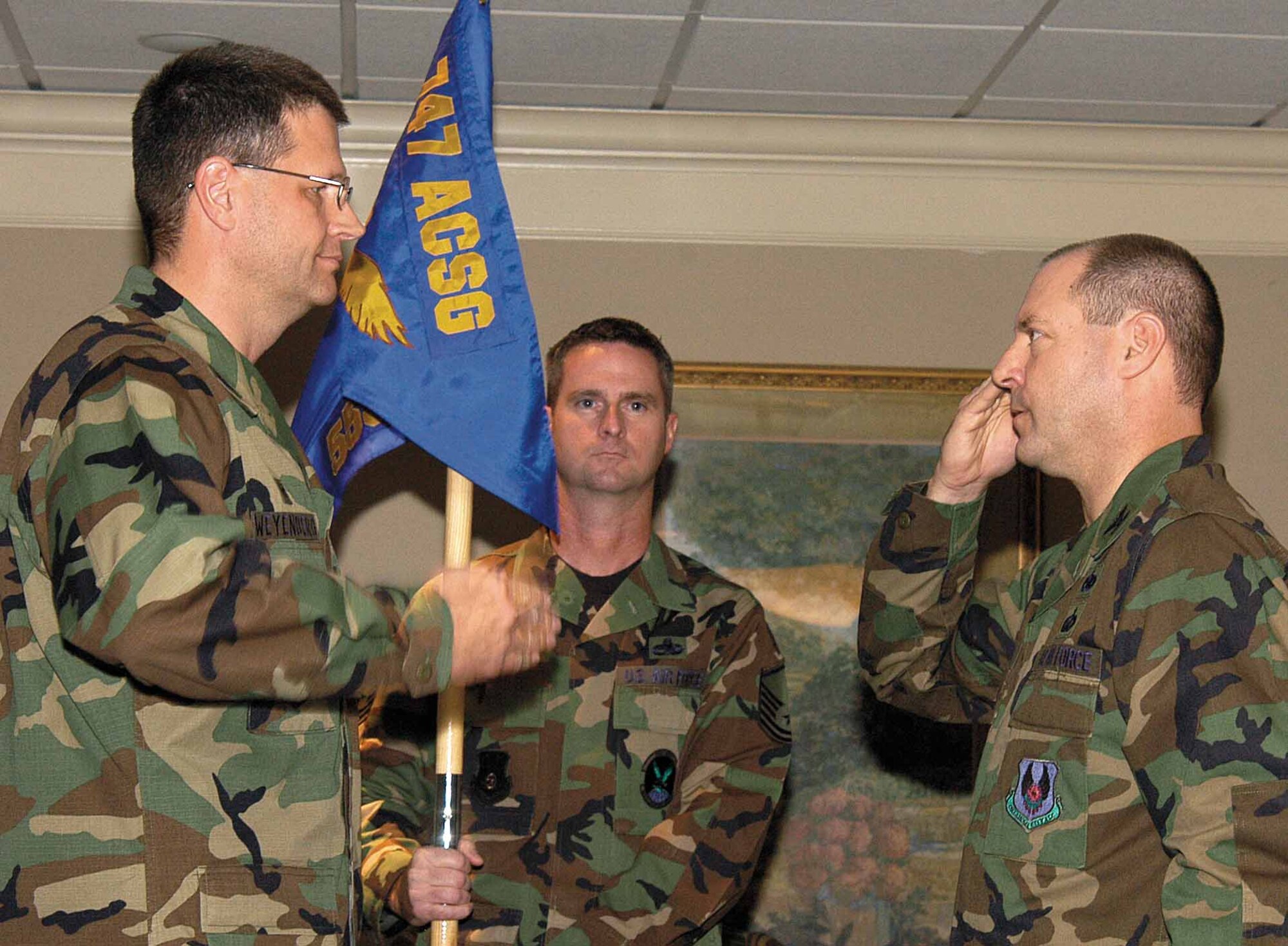 Col. Keith Weyenberg, 747th Aircraft Sustainment Group commander, transfers command of the 555th Aircraft Sustainment Squadron to Col. Michael Pelletier, right, during the Nov. 9 ceremony.  Master Sgt. Michael Rust attends the guidon. (Air Force photo by Margo Wright)
